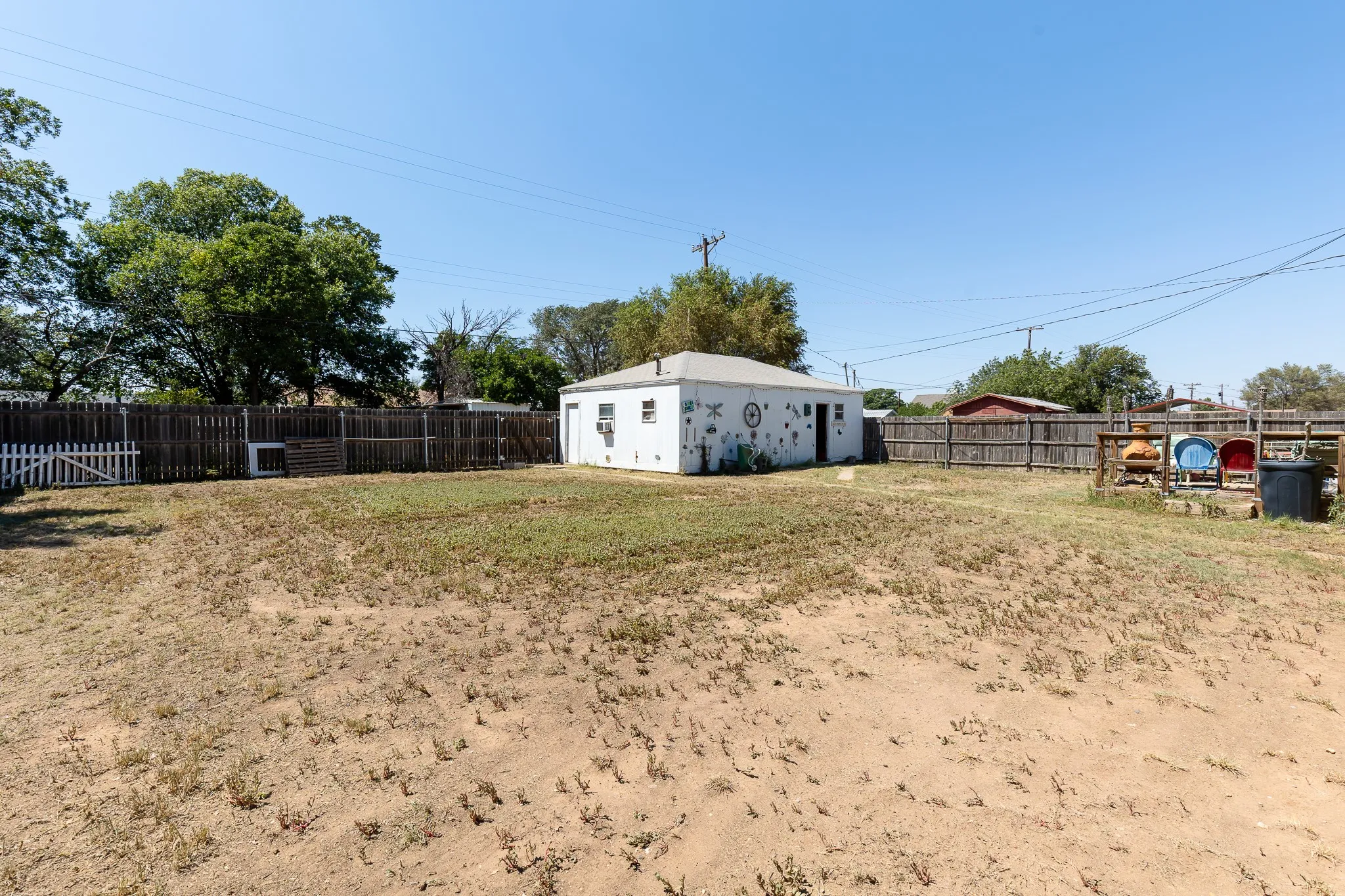 Detached structure with white exterior, multiple windows, and a side entry