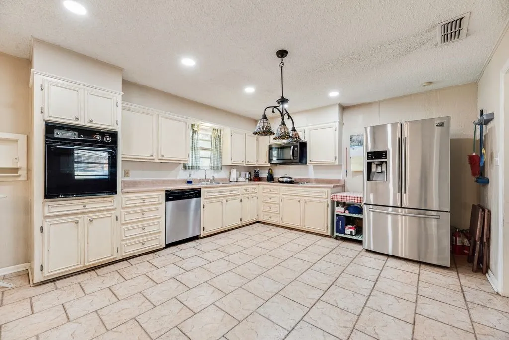 White cabinetry with built-in oven, stainless steel dishwasher, stainless steel refrigerator, and recessed lighting