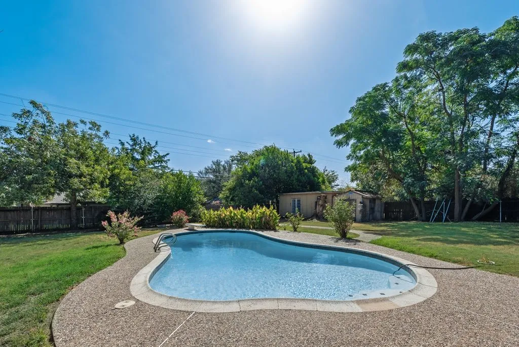 In-ground swimming pool with an exposed aggregate concrete deck