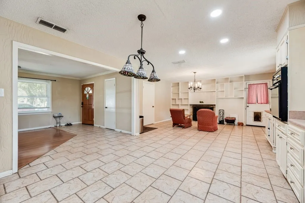 Ceramic tile flooring, built-in shelving, fireplace, recessed lighting, and kitchen cabinetry with built-in oven
