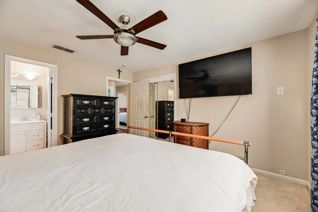 Recessed ceiling fan with light fixture, wall-mounted display, and light-toned wall paint