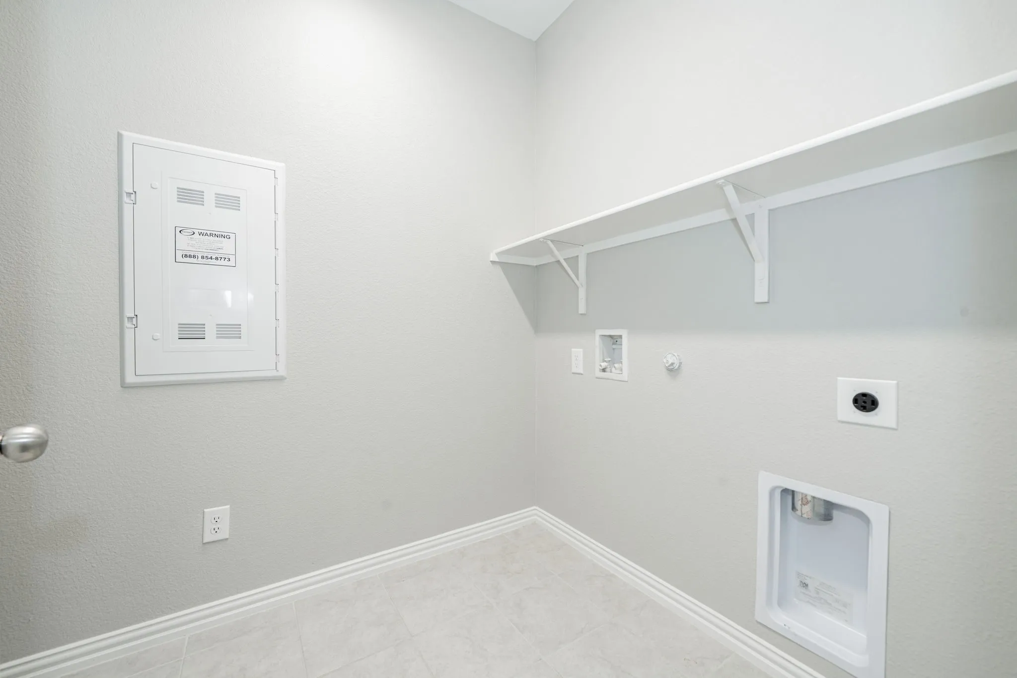 Wall-mounted shelving, neutral wall paint, and tile flooring