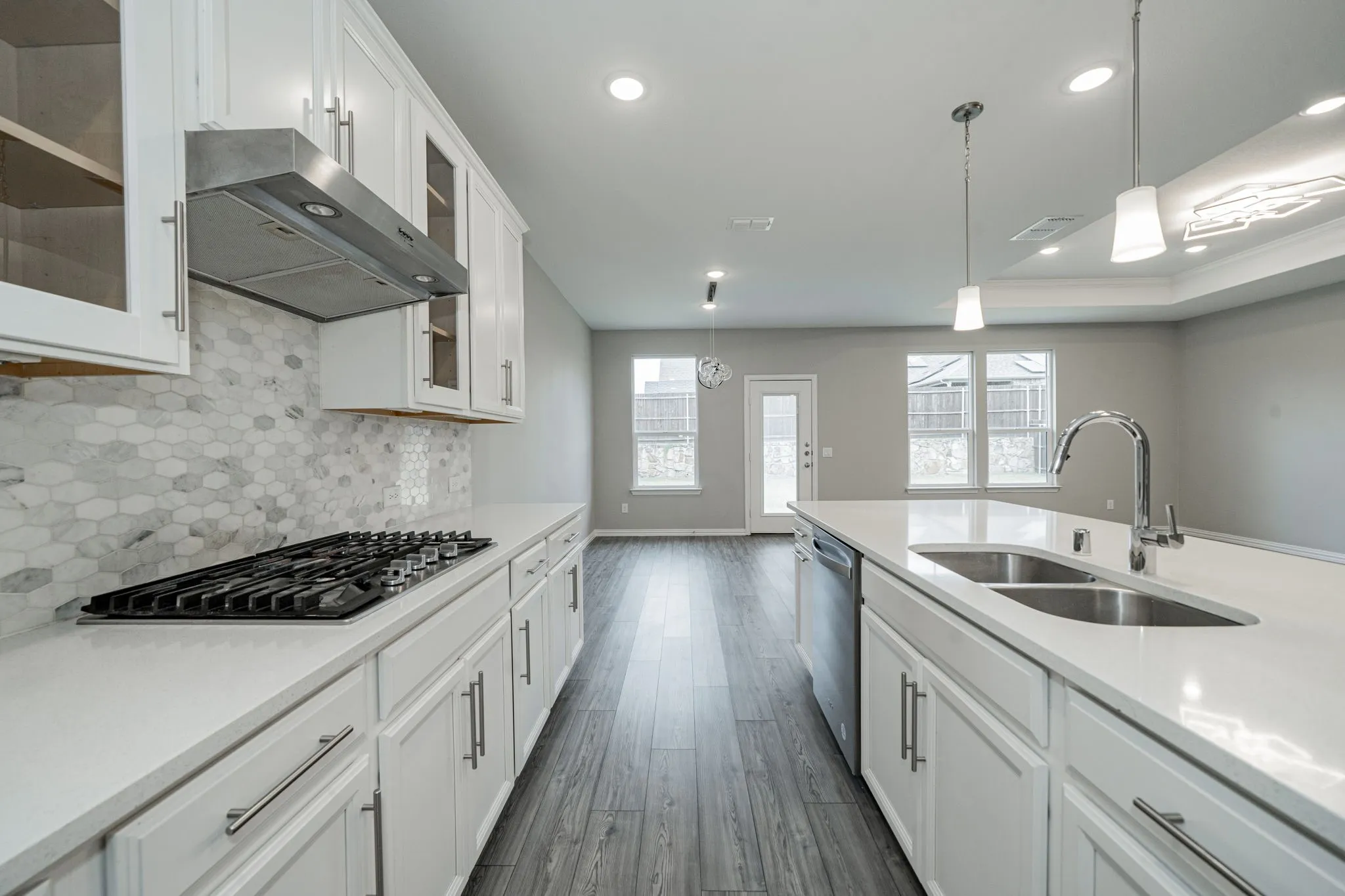 Modern kitchen with white cabinetry, stainless steel appliances, a gas cooktop, and a double basin sink