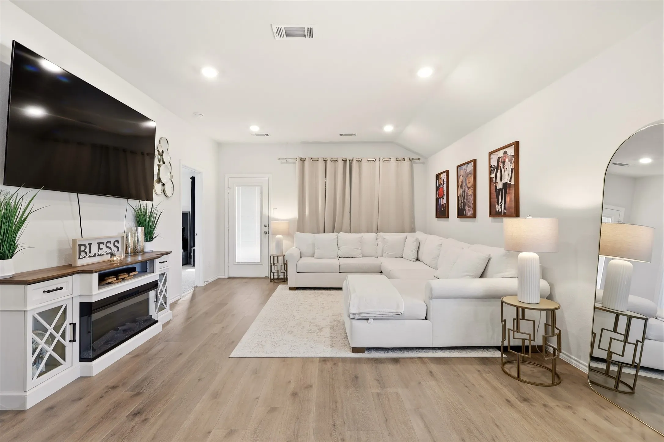 Spacious living area featuring wood-finish flooring, recessed lighting