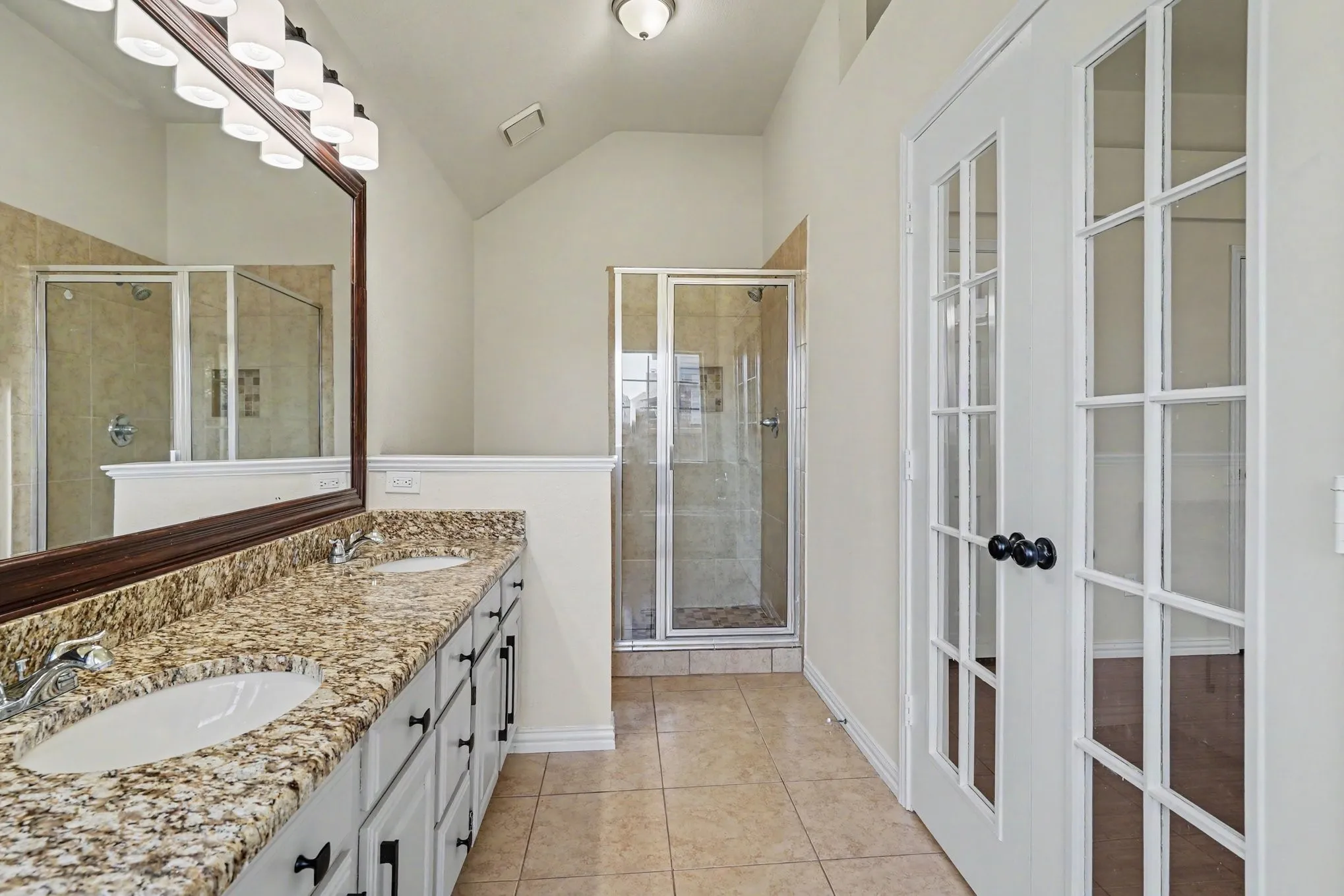 Dual vanity with undermount sinks, granite-style countertop, and ample storage