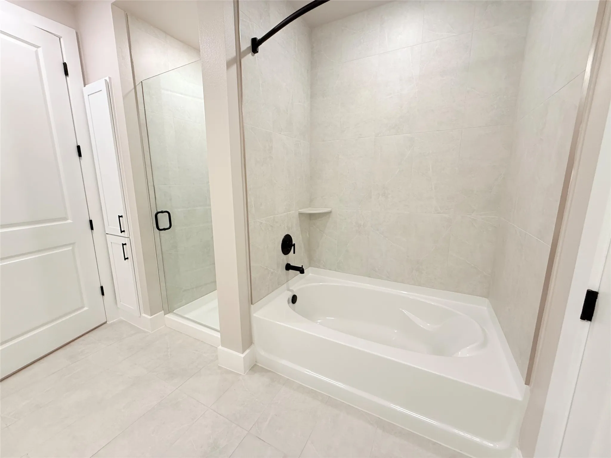 Full bath with a garden tub, a stall shower, and tile patterned flooring