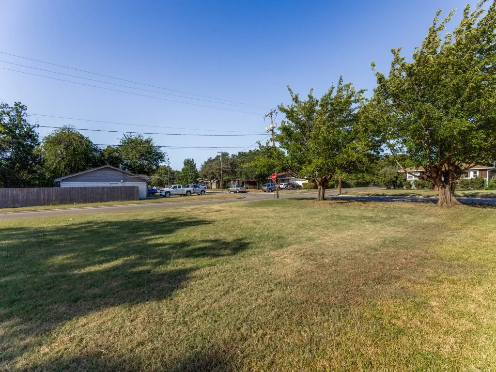 Expansive grassy yard with mature trees