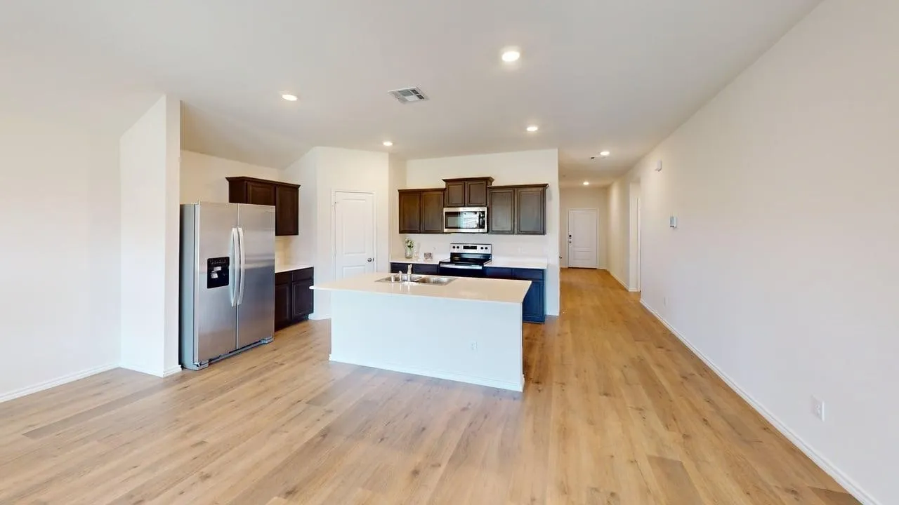 Open-concept living area featuring wood-finish flooring, recessed lighting, a kitchen island, and stainless steel appliances