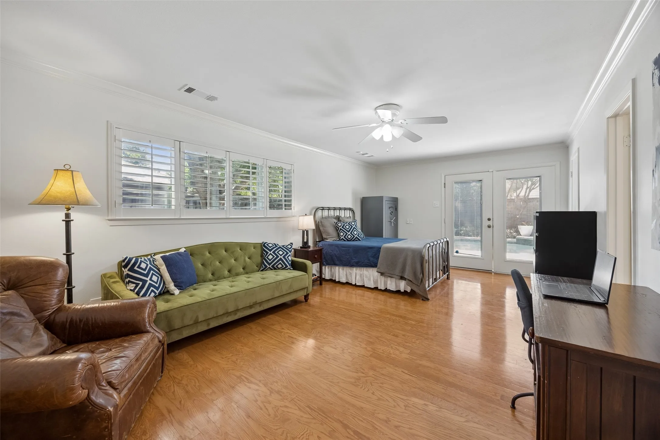 A spacious downstairs bedroom offers wood floors, french doors to the backyard and plenty of room for additional seating or a workspace. Private bathroom attached.