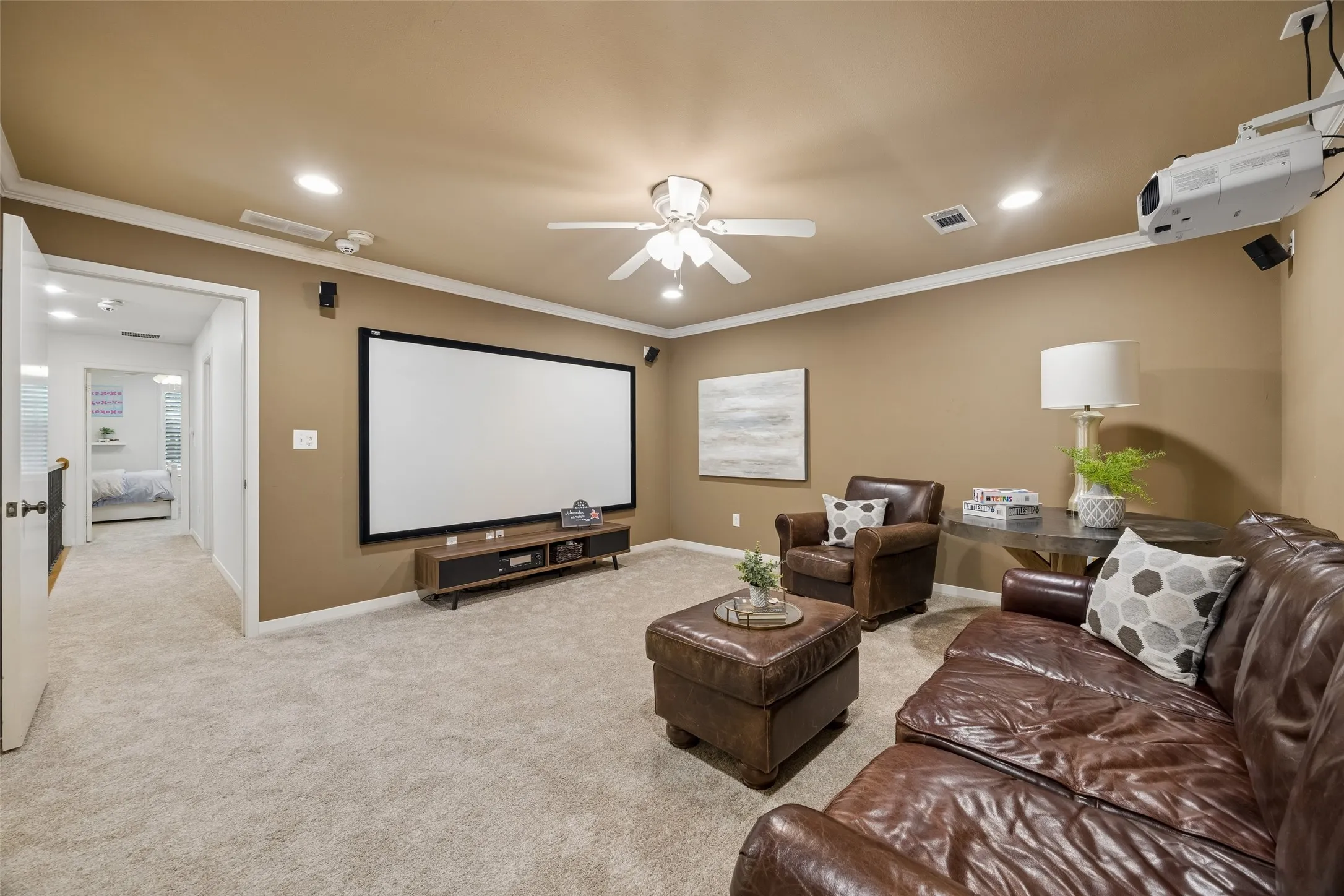 The upstairs media room with a large screen, surround sound, and plenty of space for movie nights or game-day viewing.  Additional  powder bath not photographed for guest.