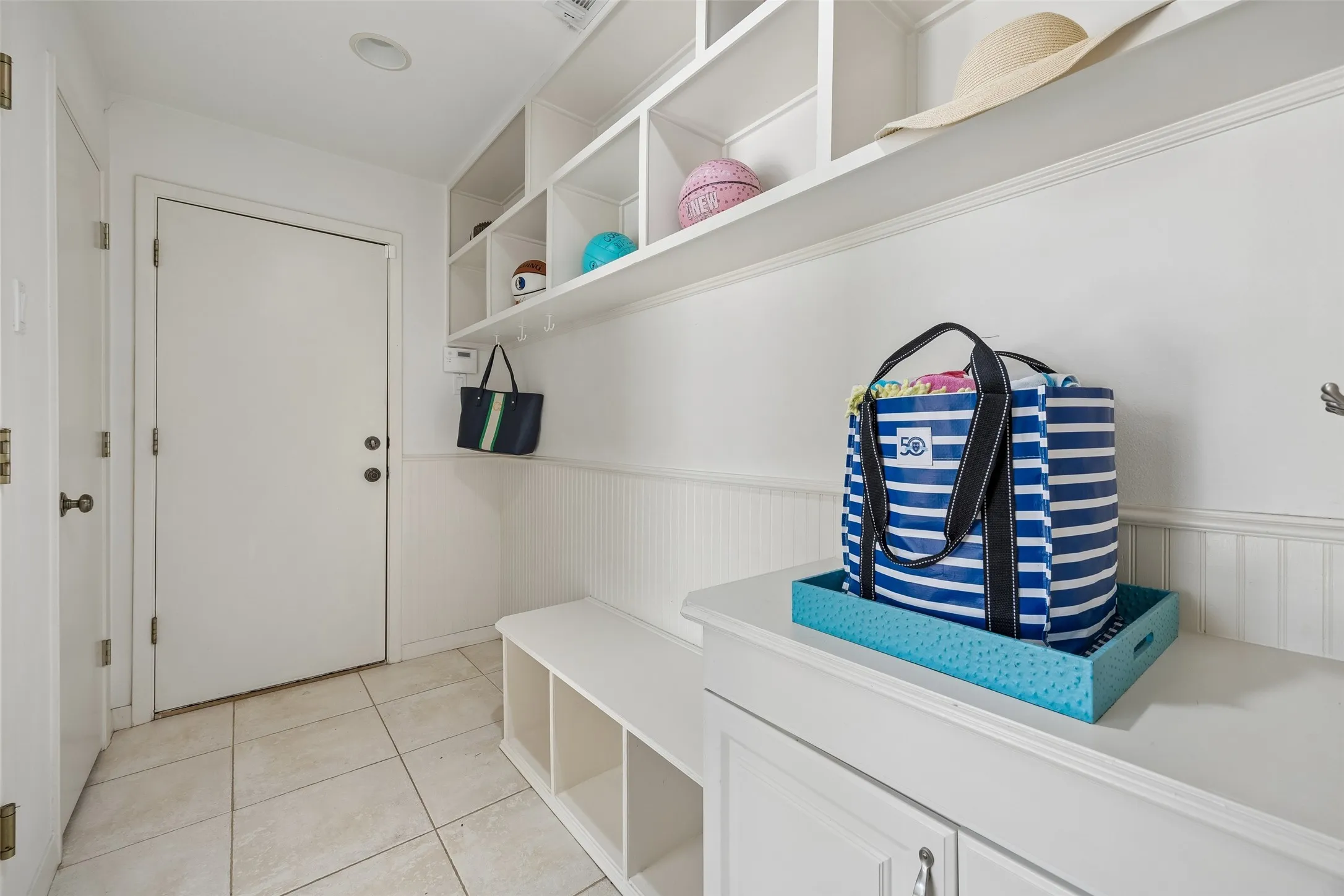 A thoughtfully designed mudroom offers built-in cubbies, hooks, bench seating, and additional storage for everyday organization.