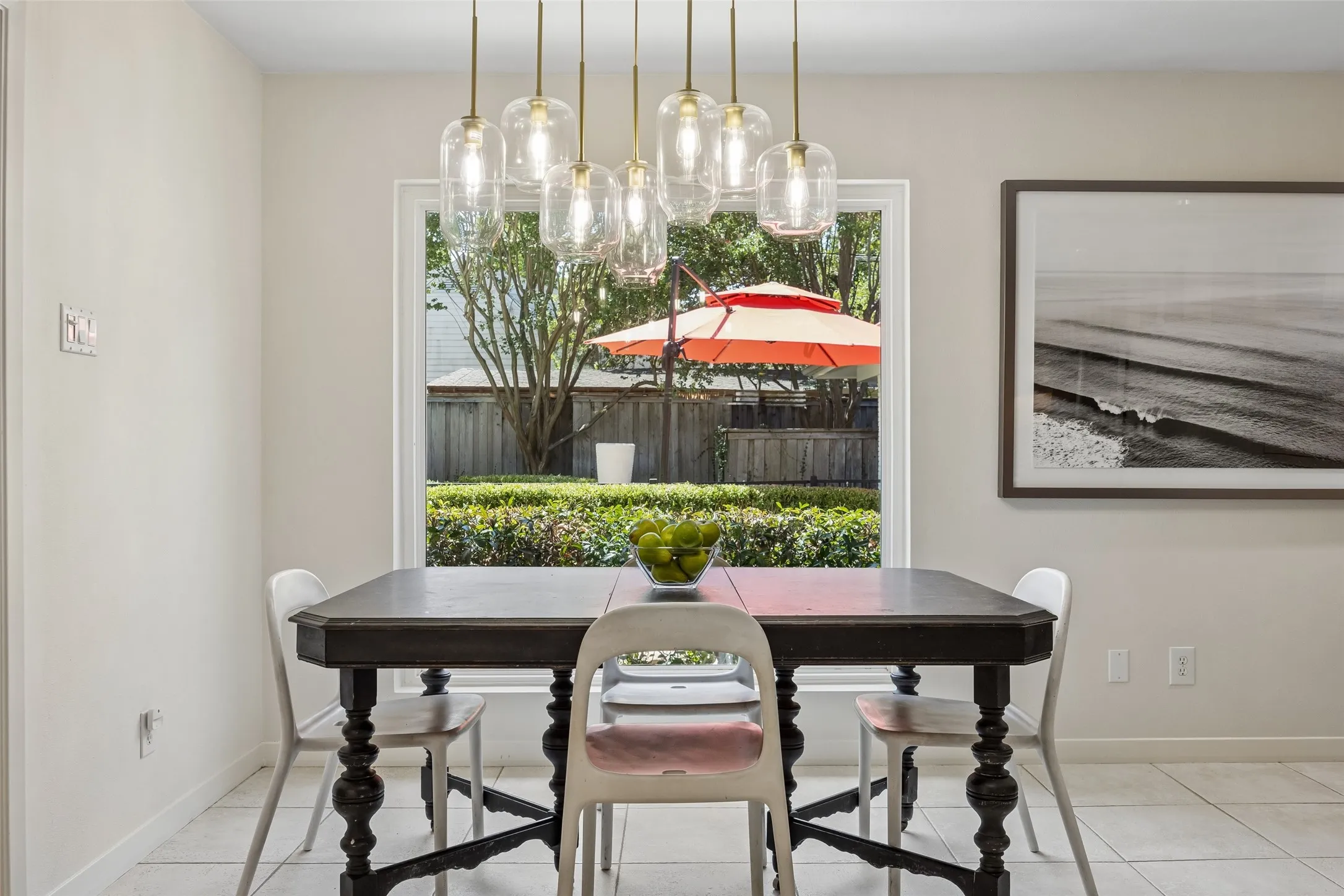 The bright breakfast nook features a statement light fixture and picturesque windows overlooking the backyard.