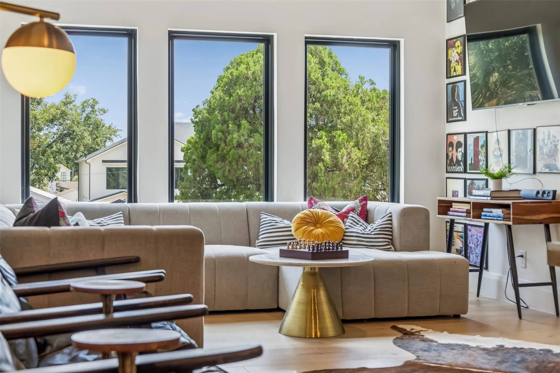 A light-filled sitting area within the upstairs game room features a wall of windows and plenty of space for lounging, games or movie nights.