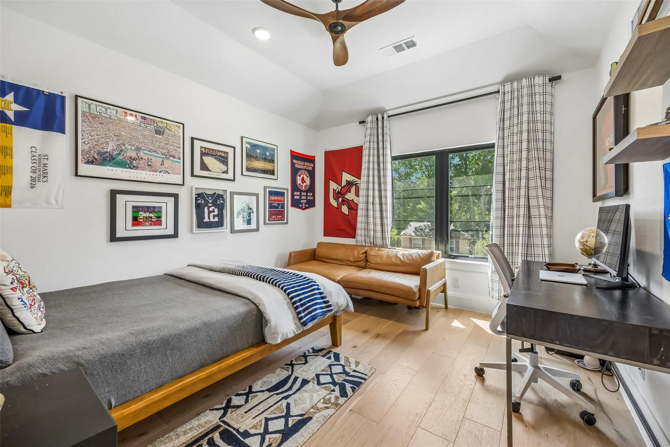 A spacious upstairs bedroom features wood floors, a vaulted ceiling, generous natural light and ample room for a sitting or study area.