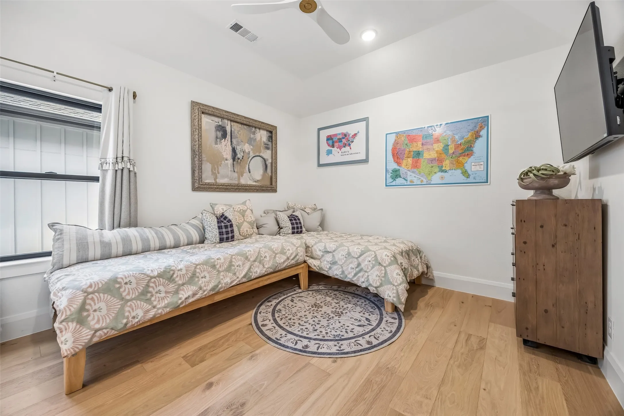 A bright upstairs bedroom features wood floors and generous natural light, with convenient access to a Jack-and-Jill bath shared with the adjoining bedroom.