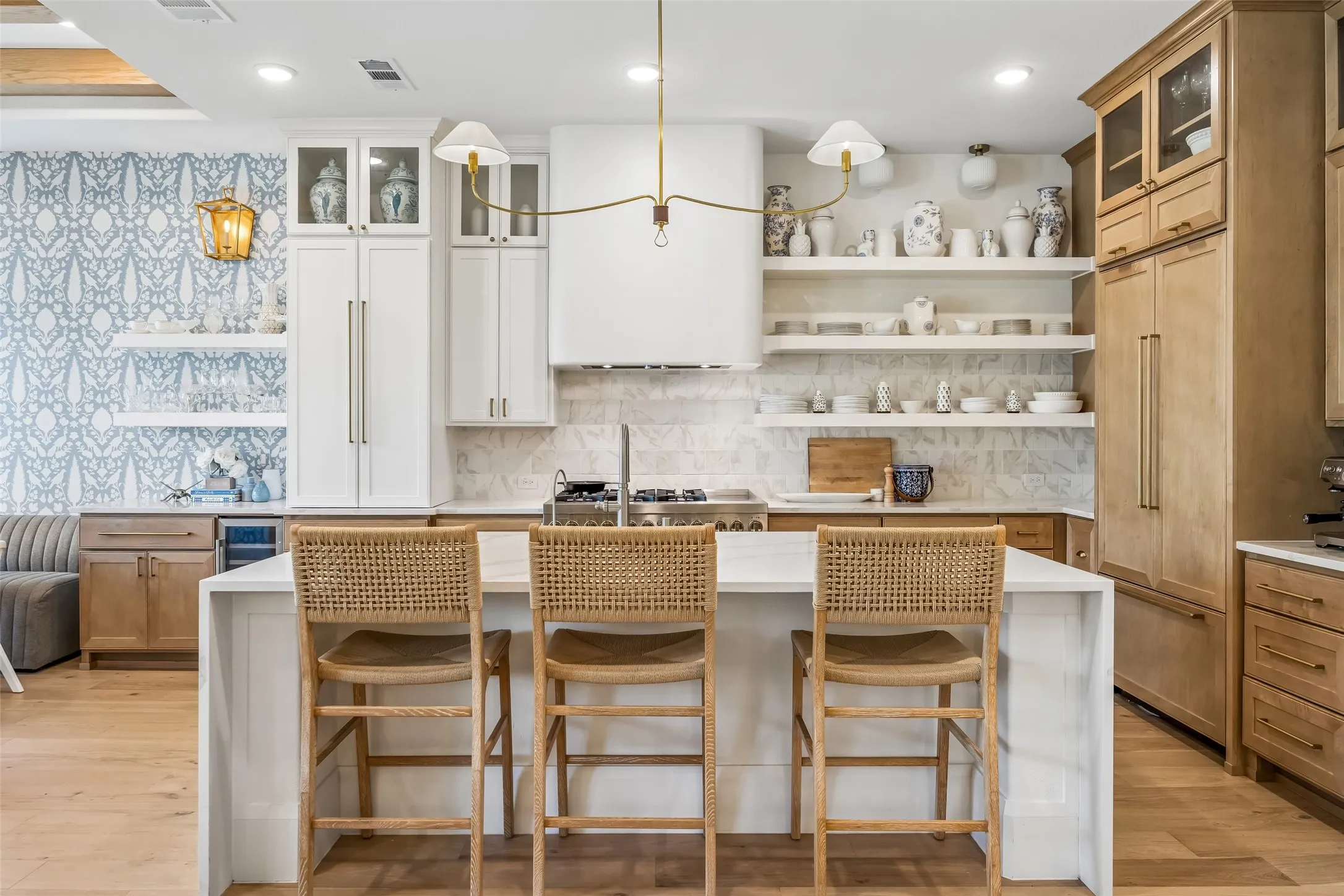 A beautifully designed kitchen balances warmth and sophistication with custom cabinetry, a statement island, marble-inspired surfaces, designer lighting and thoughtfully selected finishes, creating a polished yet inviting space for cooking and gathering.