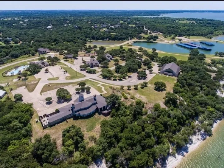 Expansive property featuring multiple buildings, surface parking areas, a swimming pool, and natural waterways