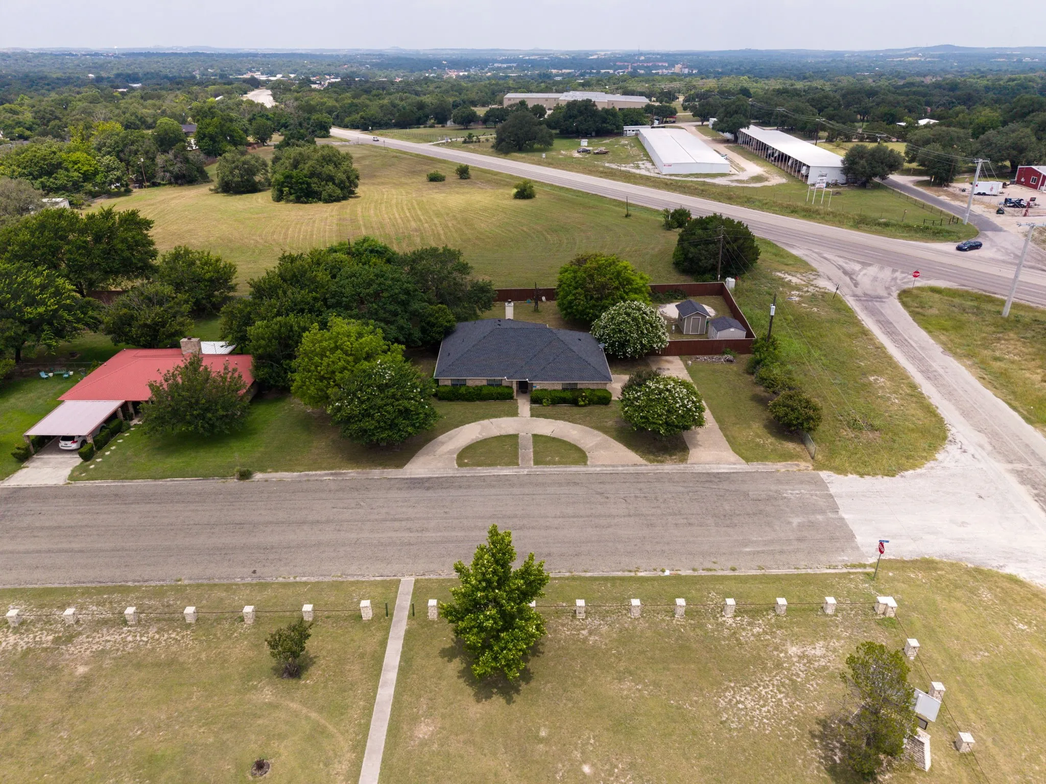 Single-story residence with a dark shingle roof, established landscaping, and a fenced backyard