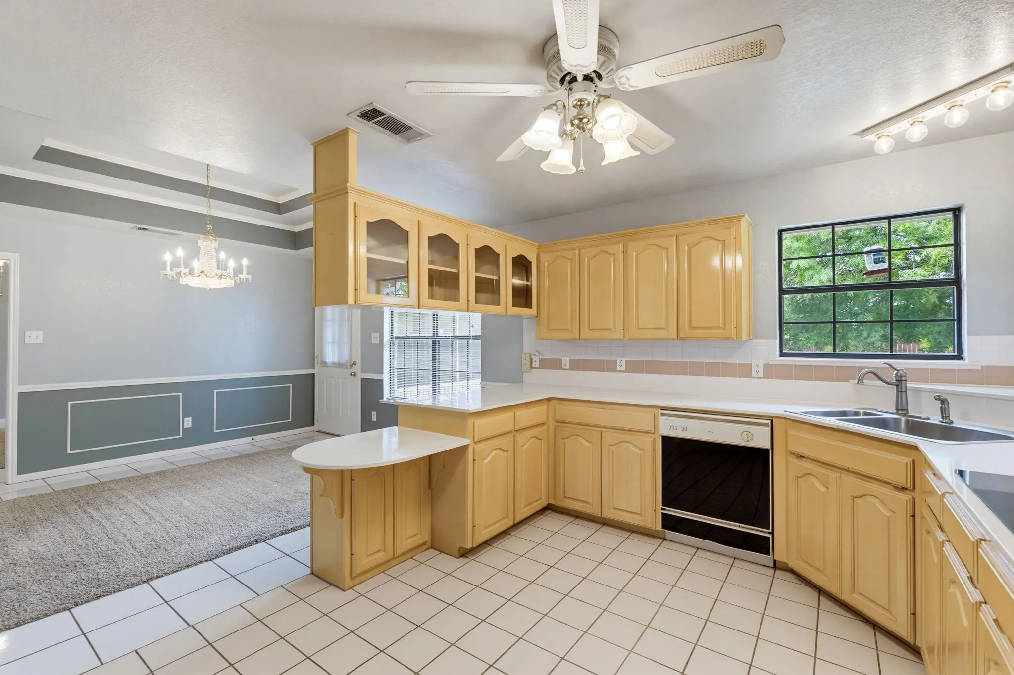 Kitchen featuring wood cabinetry, white countertops, tile flooring, and a ceiling fan