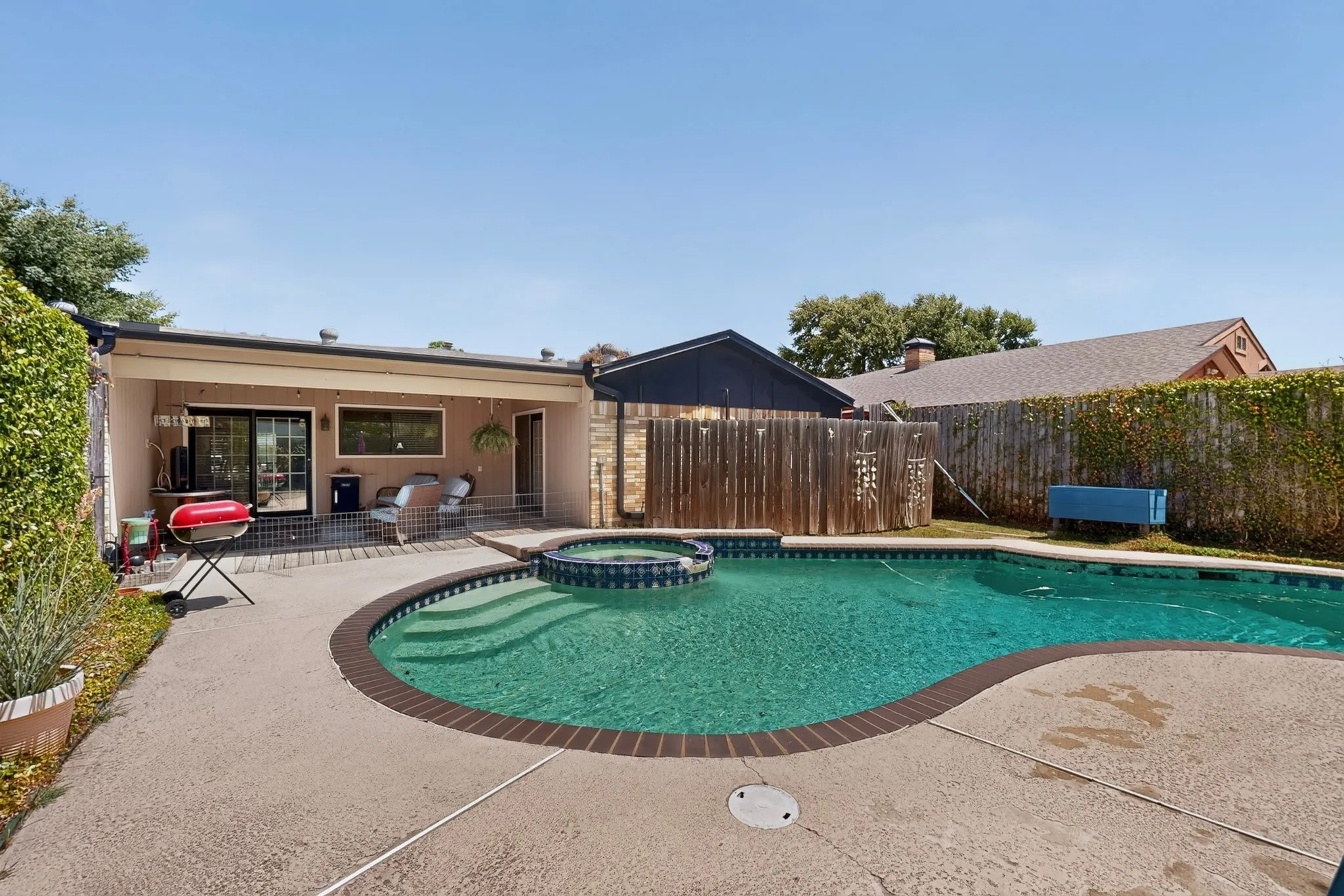 Outdoor swimming pool with integrated spa and concrete decking