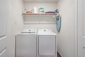 Laundry area featuring a built-in shelf and white walls