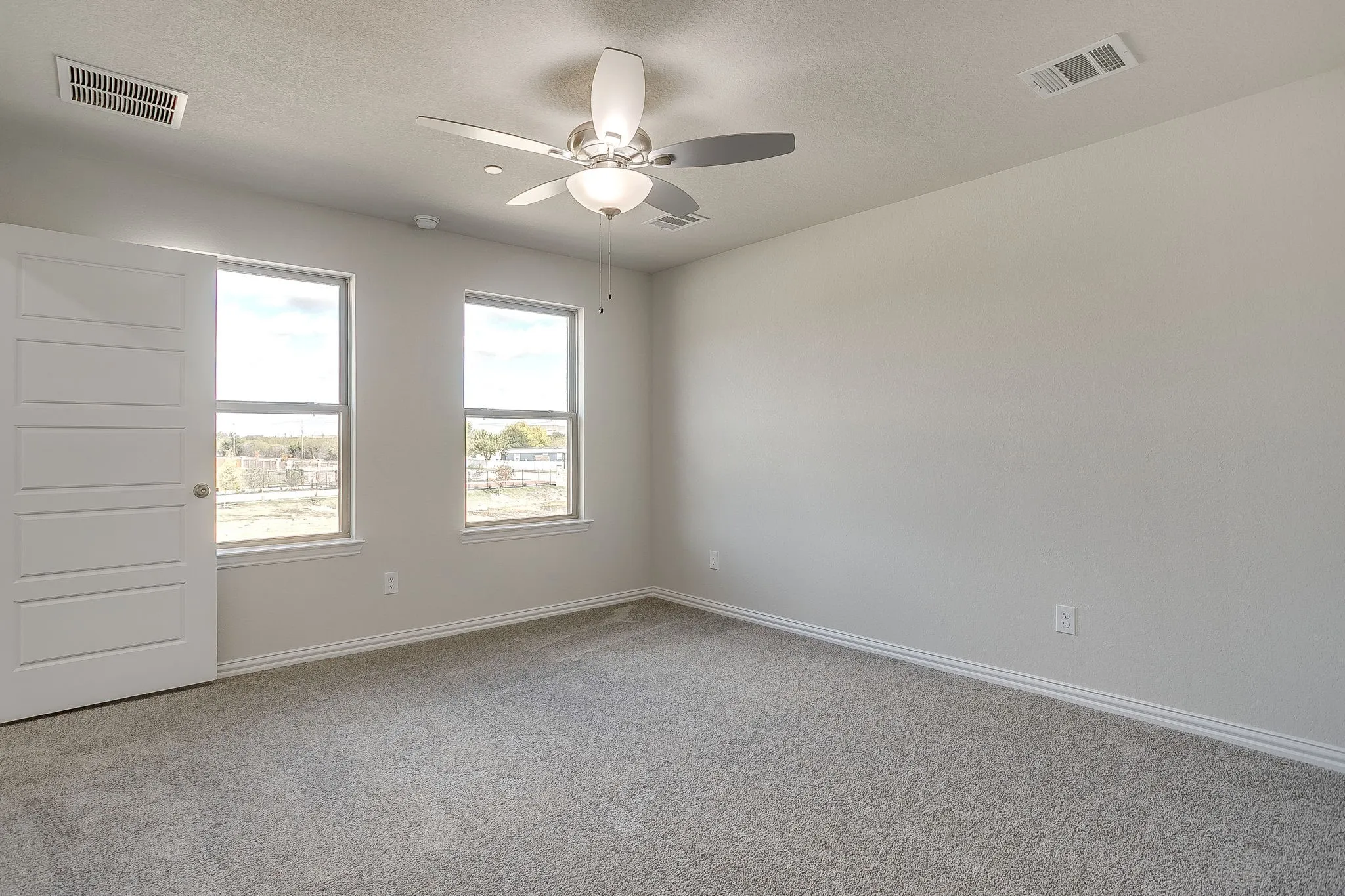 Empty room with light carpet and ceiling fan