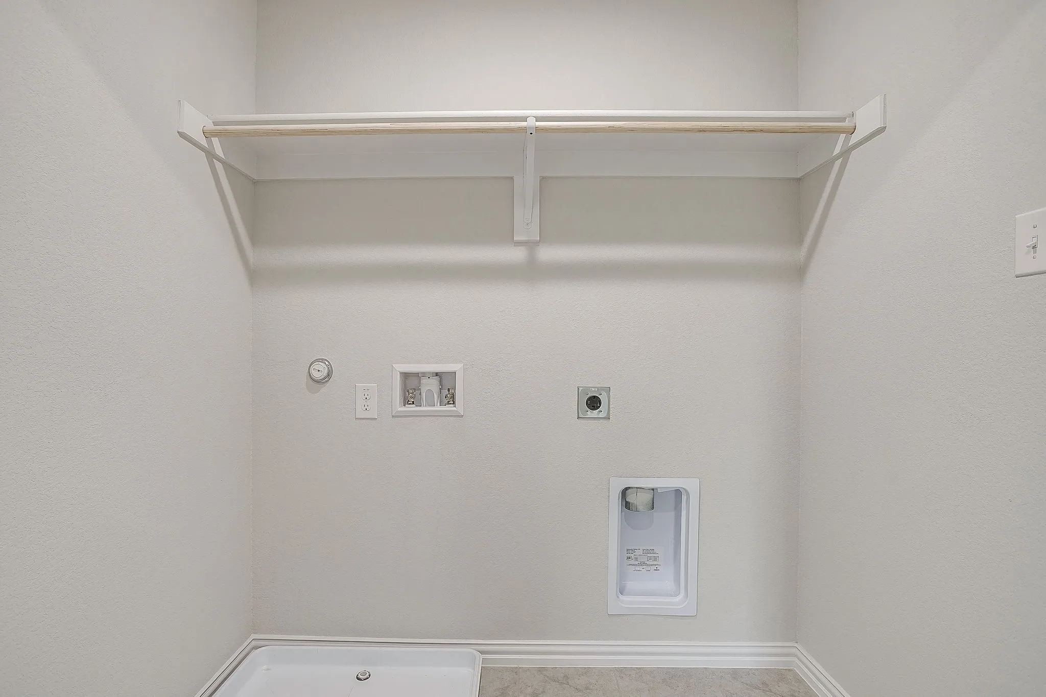 Washroom with hookup for a gas dryer, hookup for a washing machine, and hookup for an electric dryer