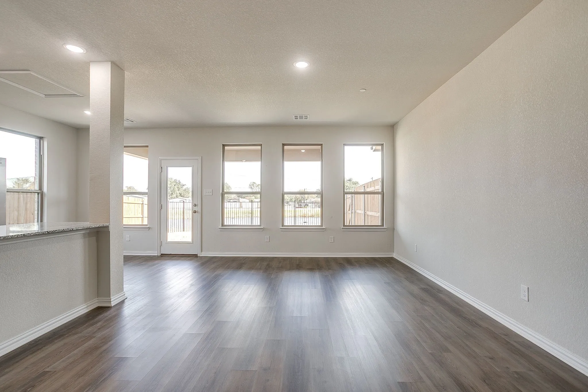 Unfurnished room with dark wood finished floors, a textured wall, a textured ceiling, and recessed lighting