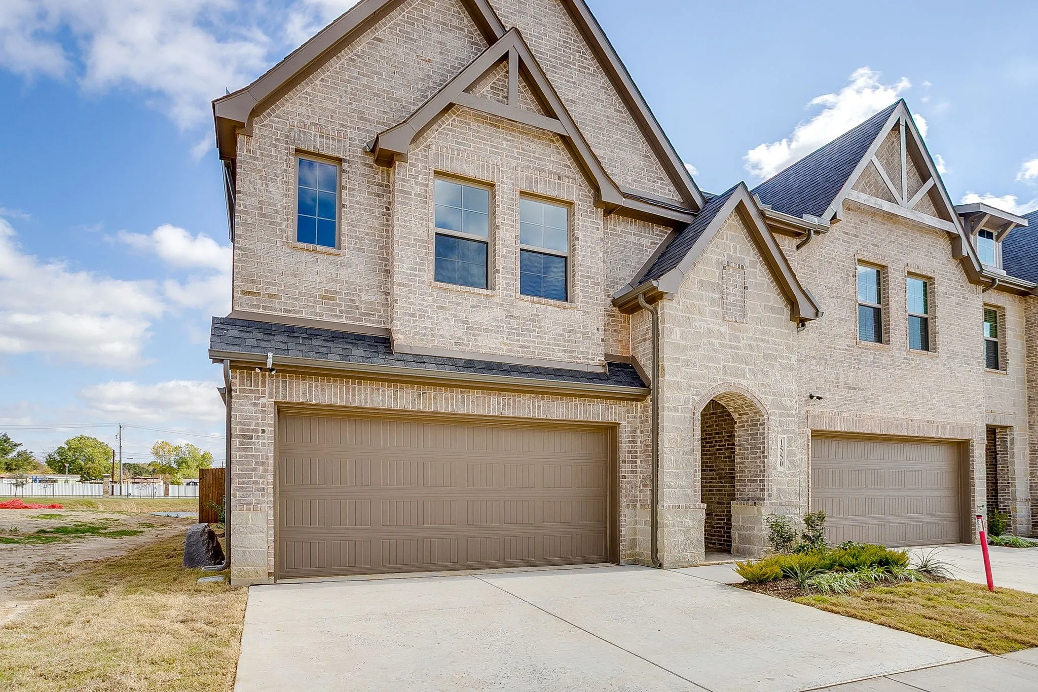 View of front of property with brick siding, concrete driveway, and a garage