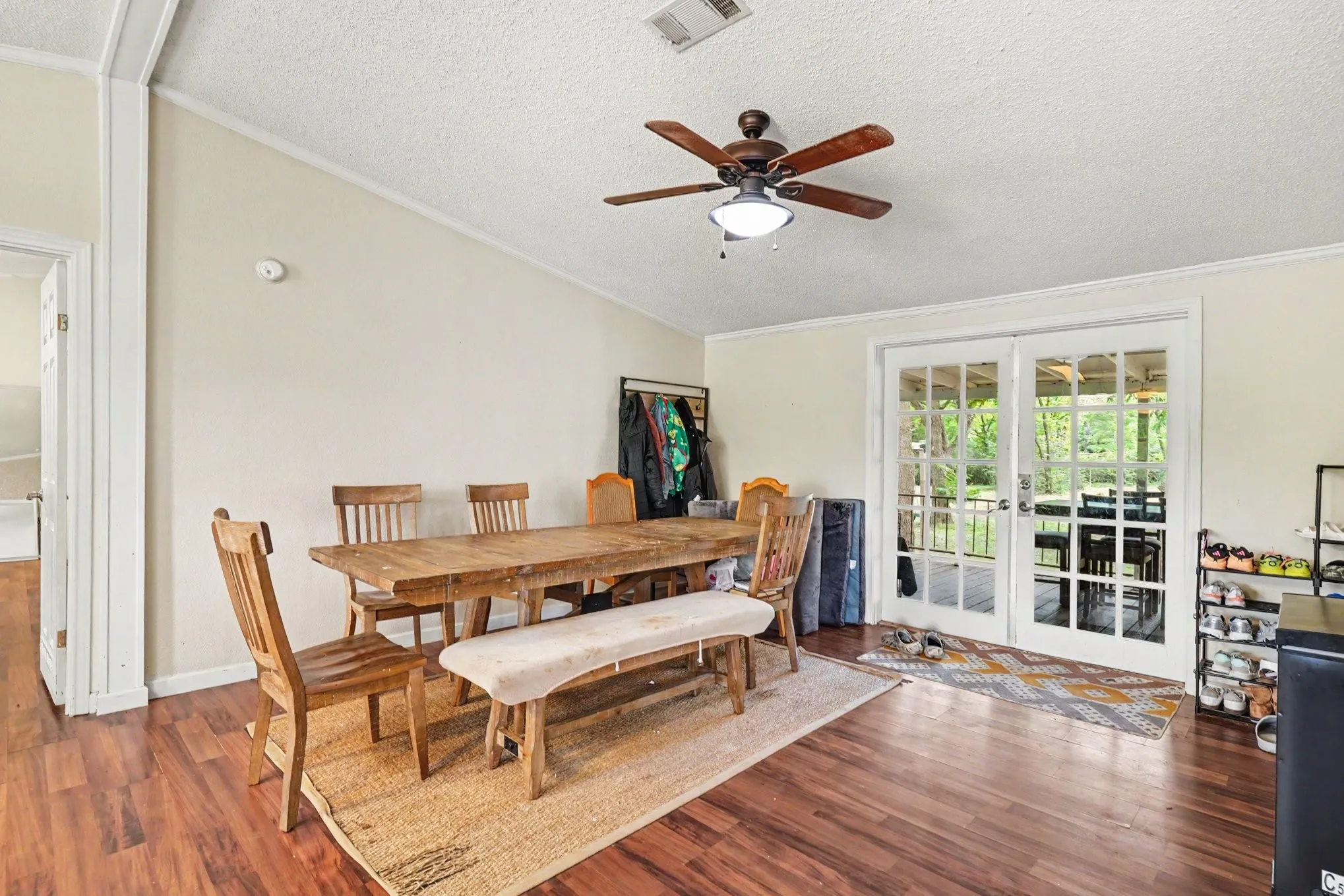 Interior space featuring wood-finish flooring, vaulted ceiling, and a ceiling fan with integrated lighting