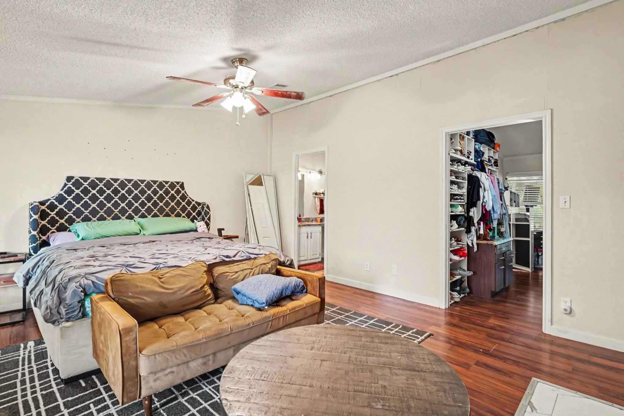 Spacious room featuring wood-finish flooring and a ceiling fan with integrated lighting