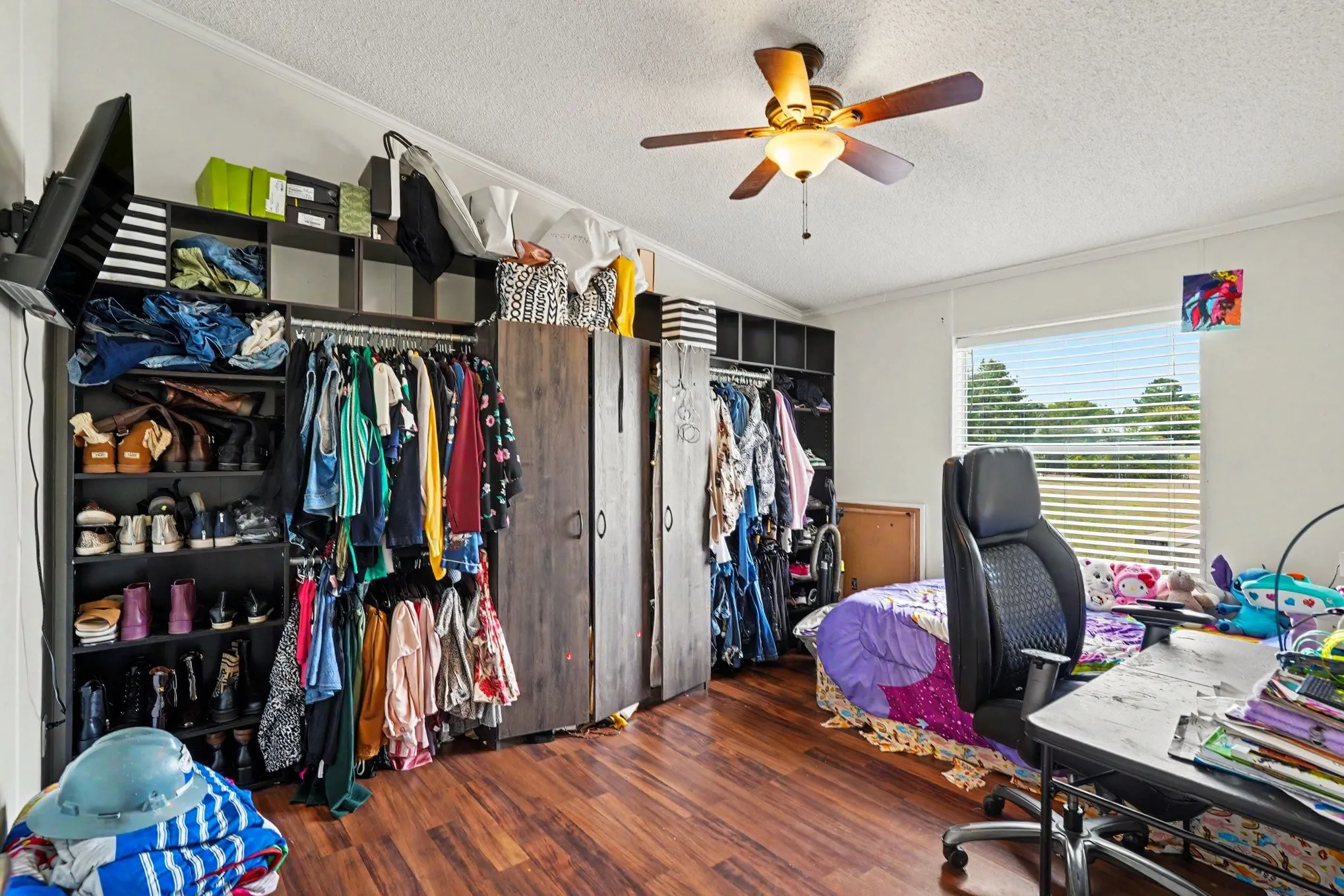 Spacious room featuring wood-finish flooring and a ceiling fan with integrated lighting