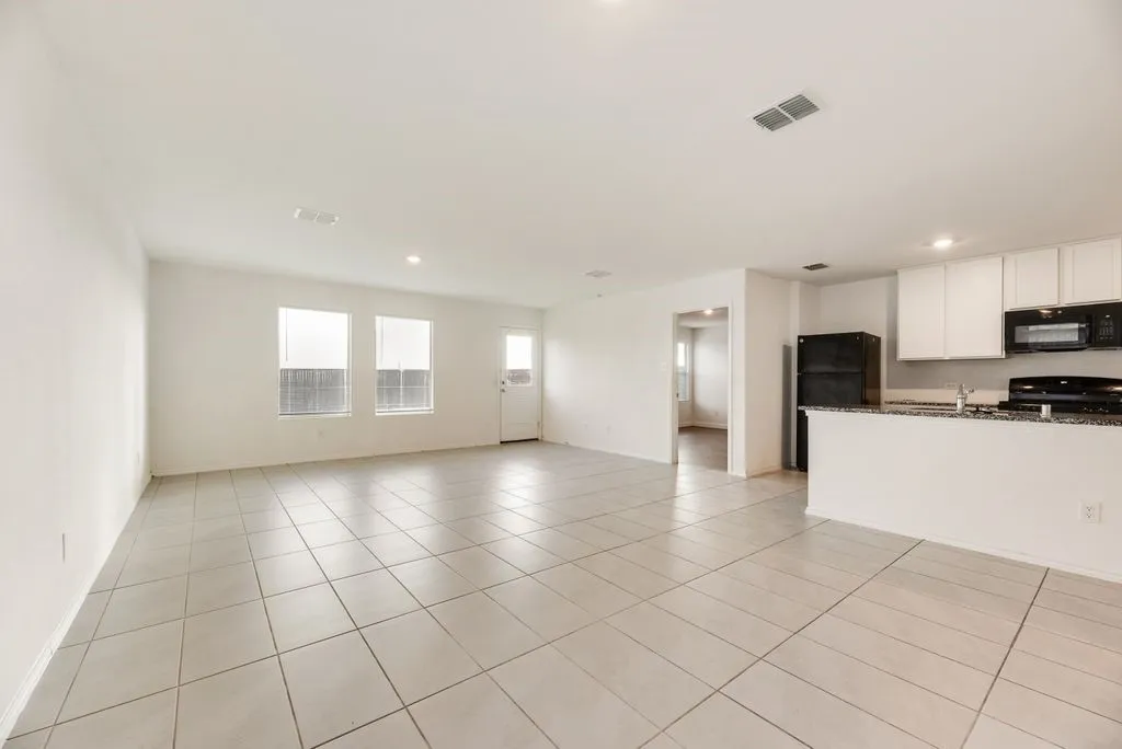 Open-concept living space with light-toned square tile flooring throughout