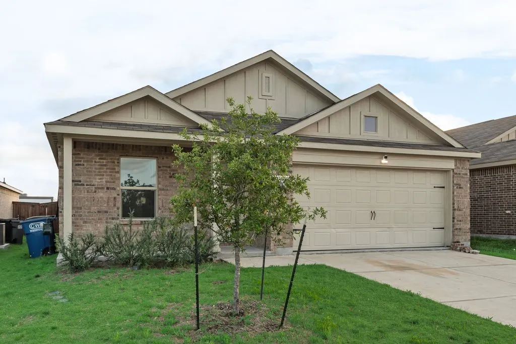 Brick and siding exterior featuring a two-car garage with decorative hardware