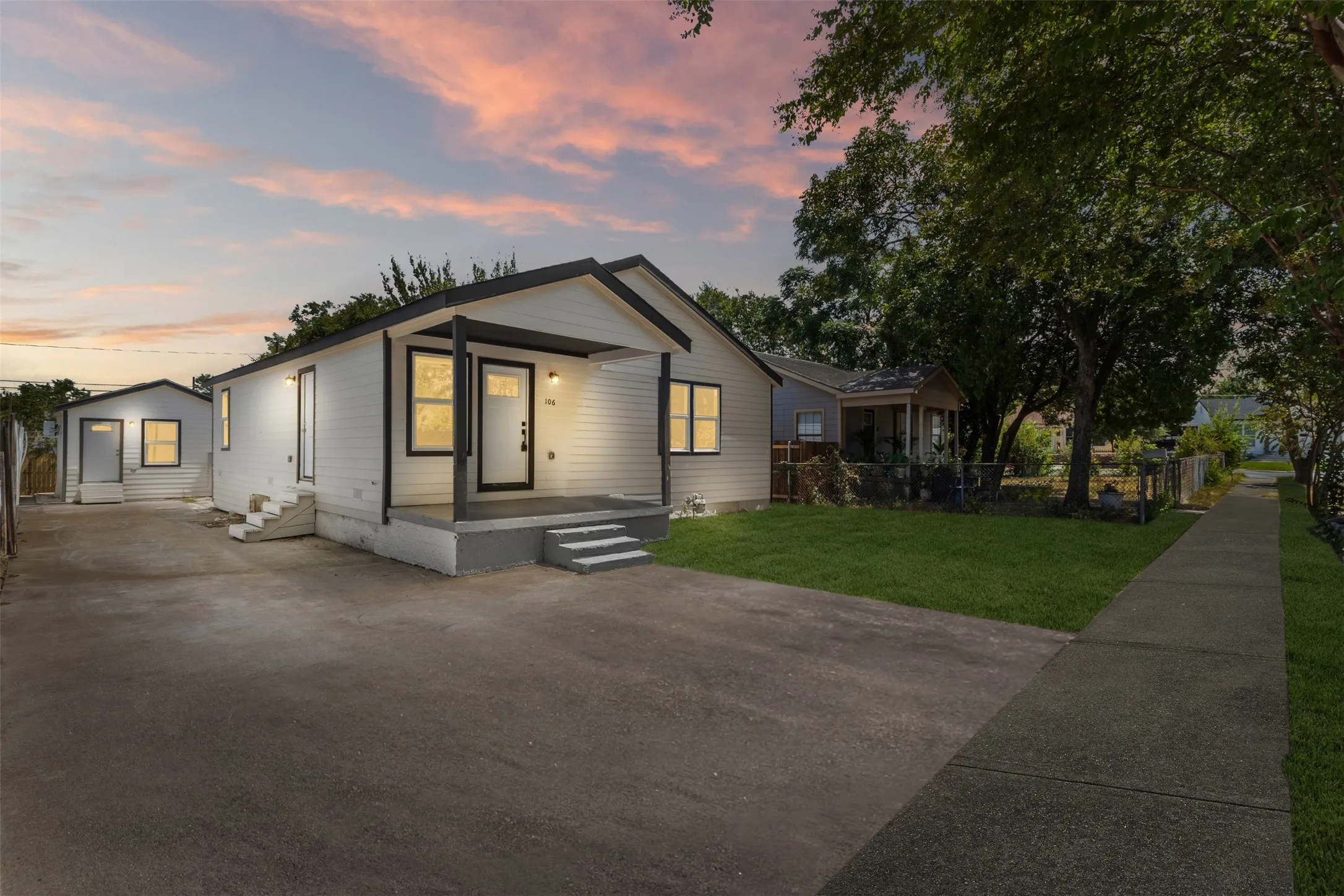 Contemporary exterior with white siding, black trim, and a covered front porch
