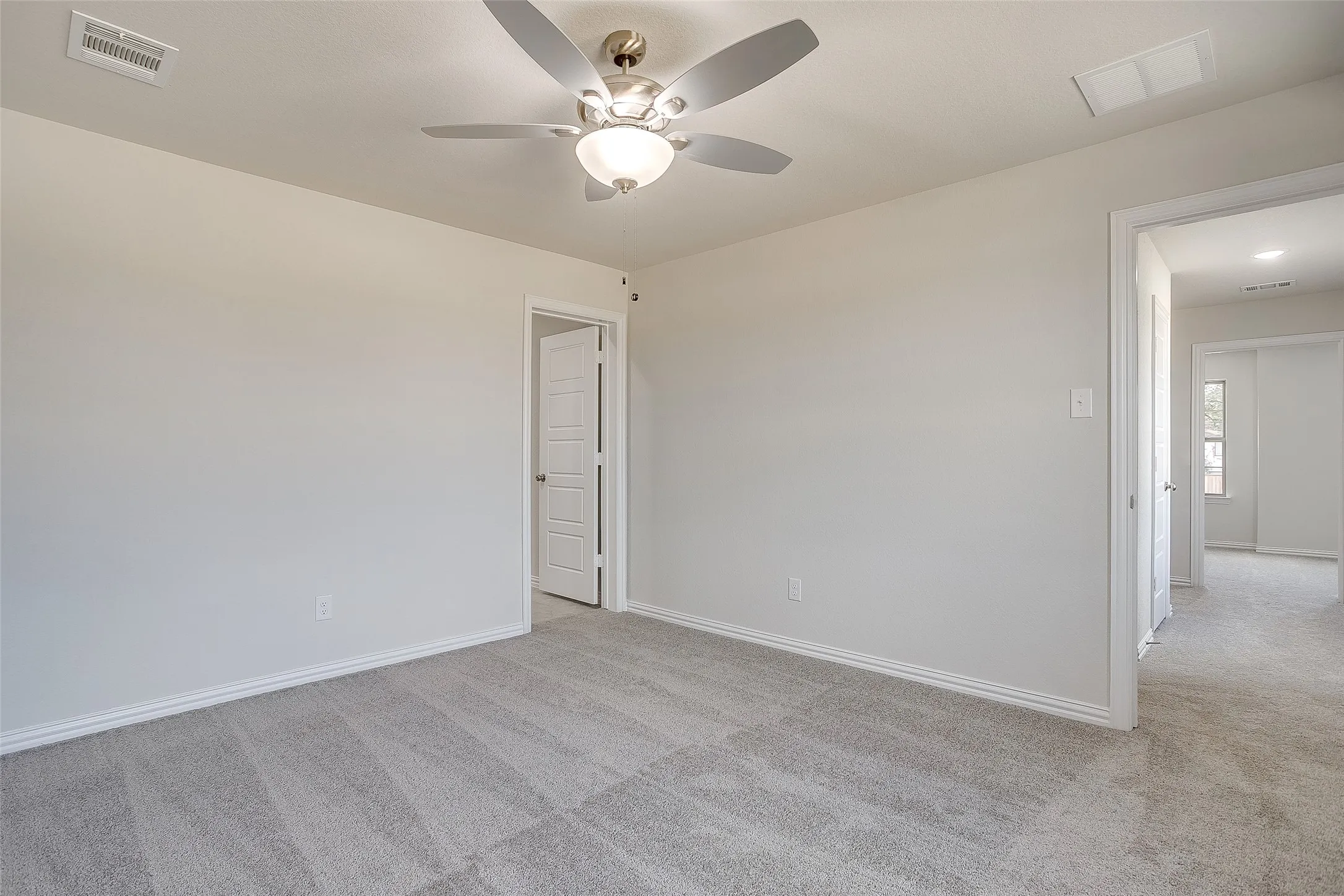 Unfurnished room featuring light carpet and a ceiling fan