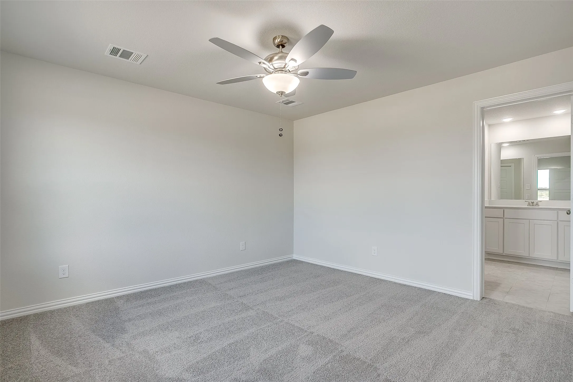 Unfurnished room featuring light colored carpet and ceiling fan