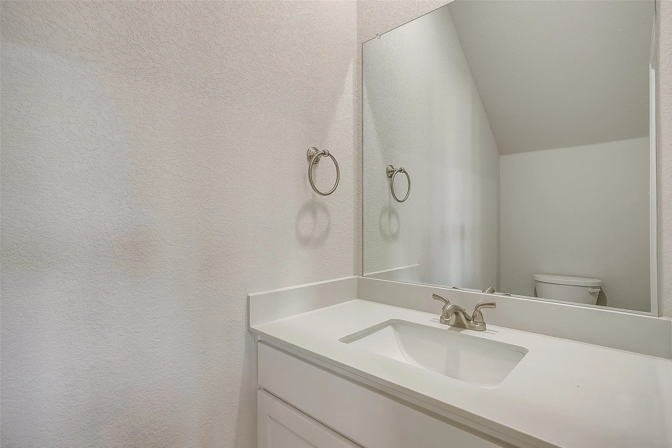 Bathroom featuring vanity and a textured wall