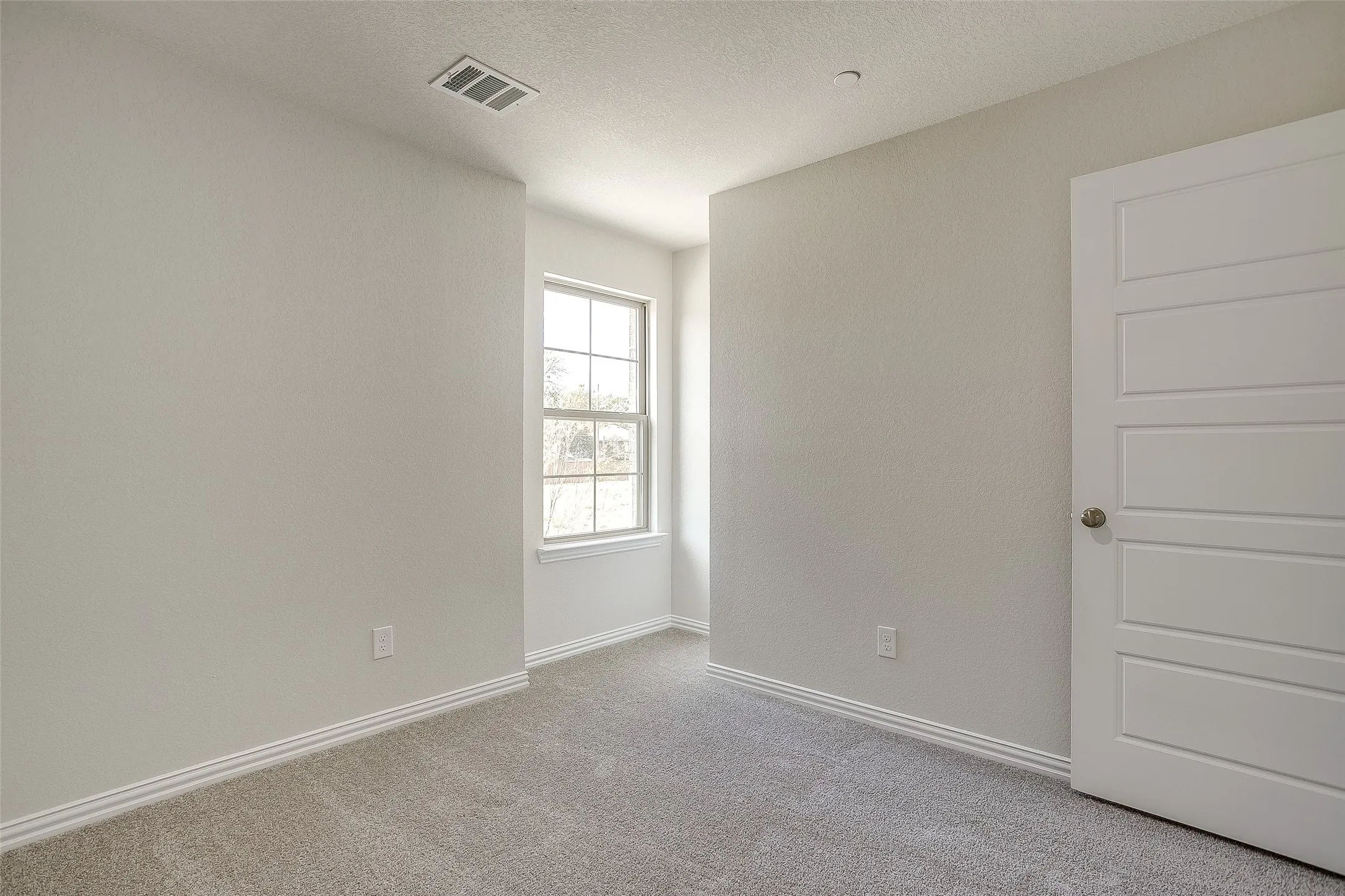 Spare room with carpet floors and a textured ceiling