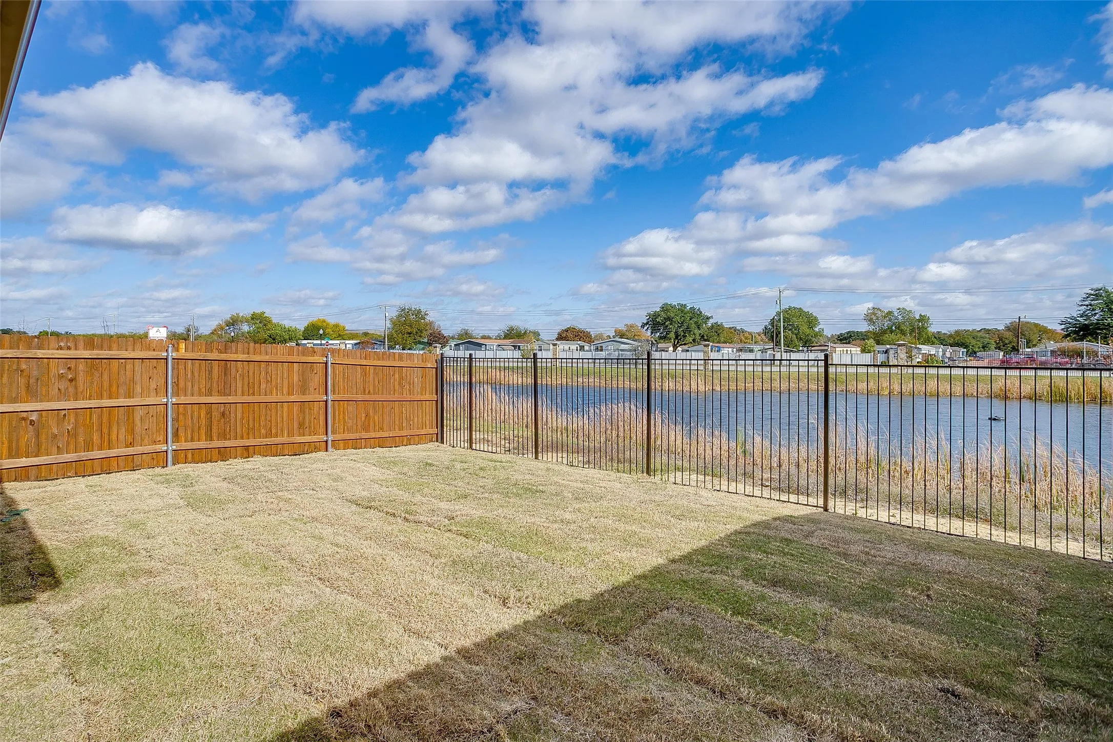 Fenced backyard with a water view