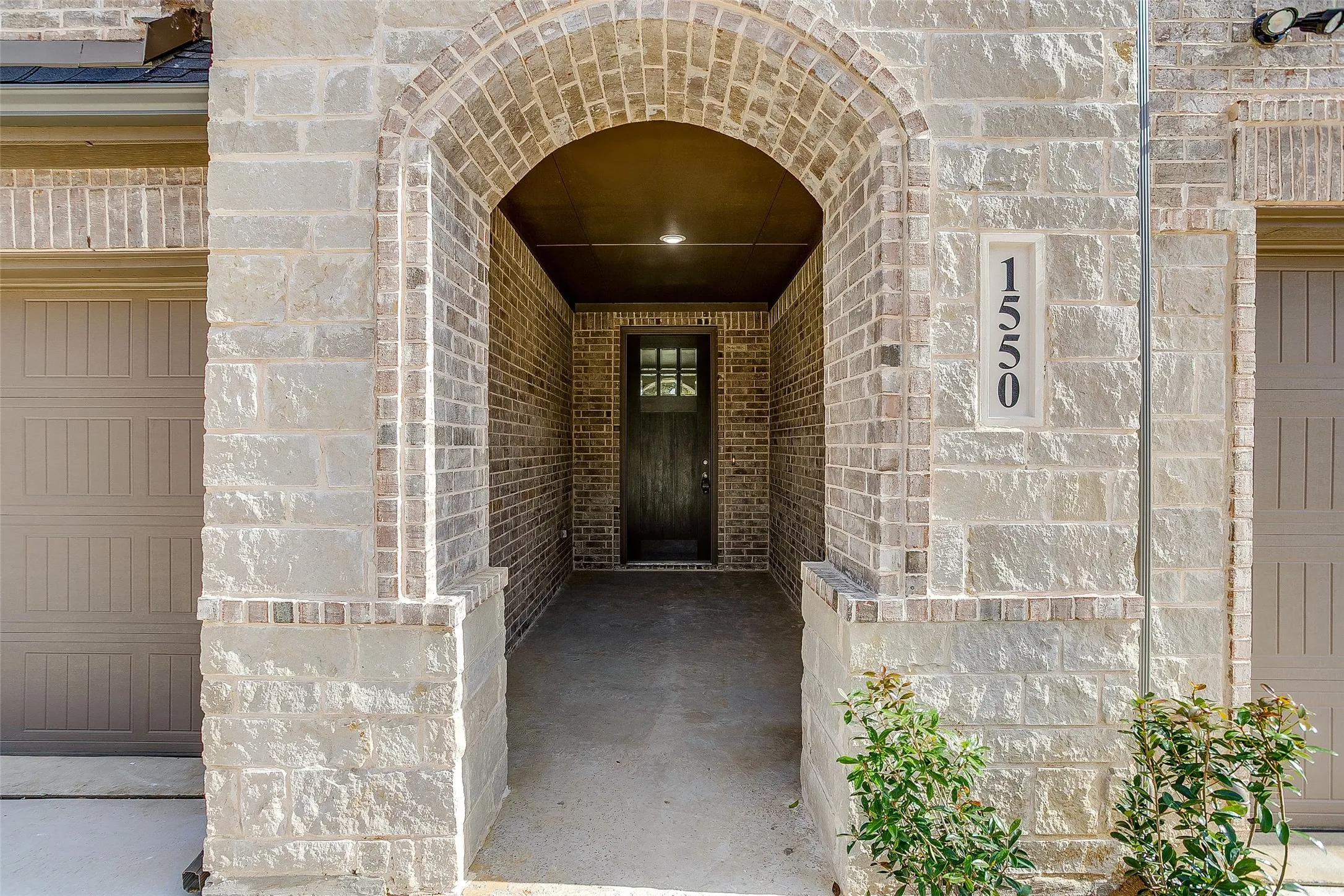 Property entrance featuring stone siding and brick siding