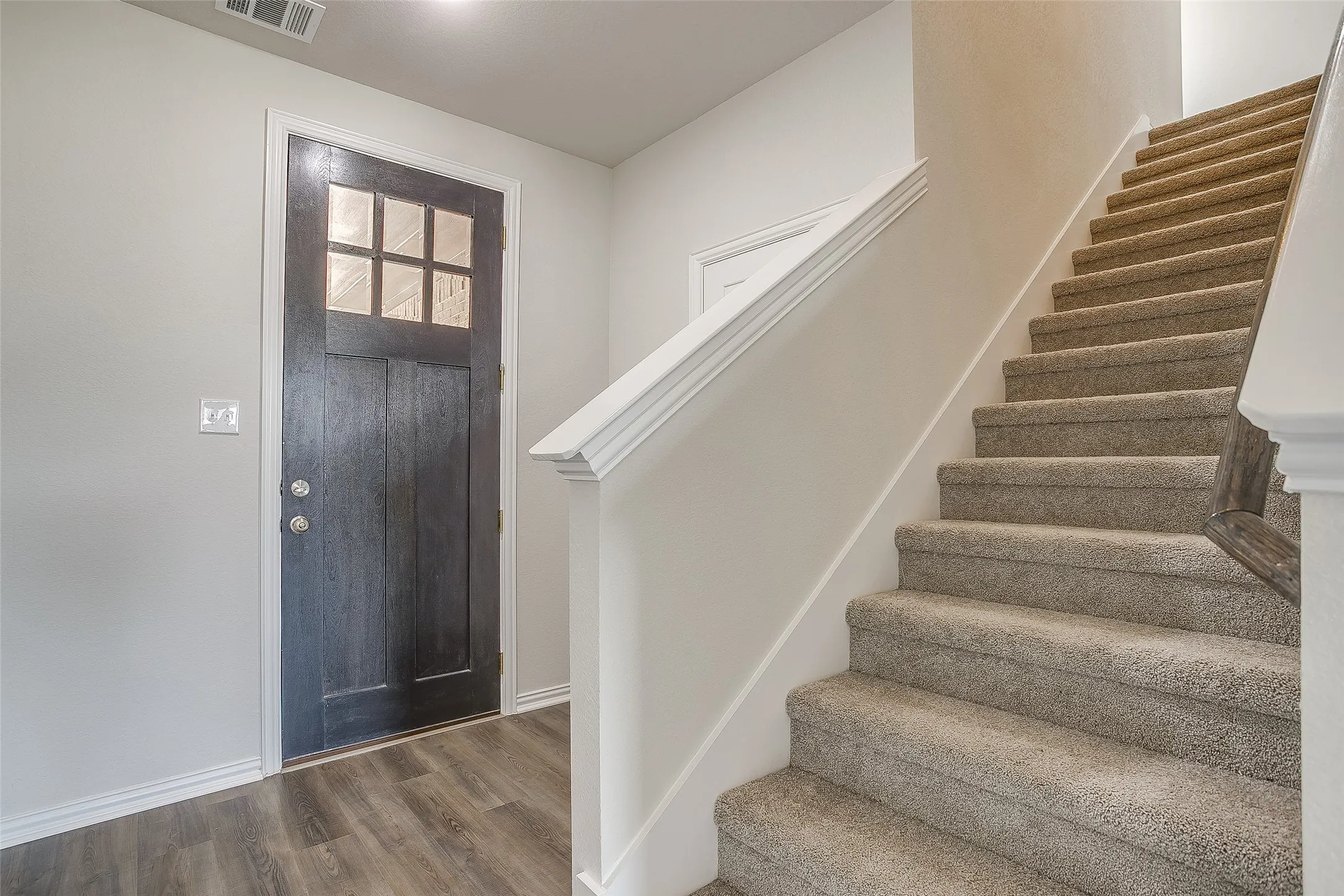 Foyer entrance with wood finished floors and stairs
