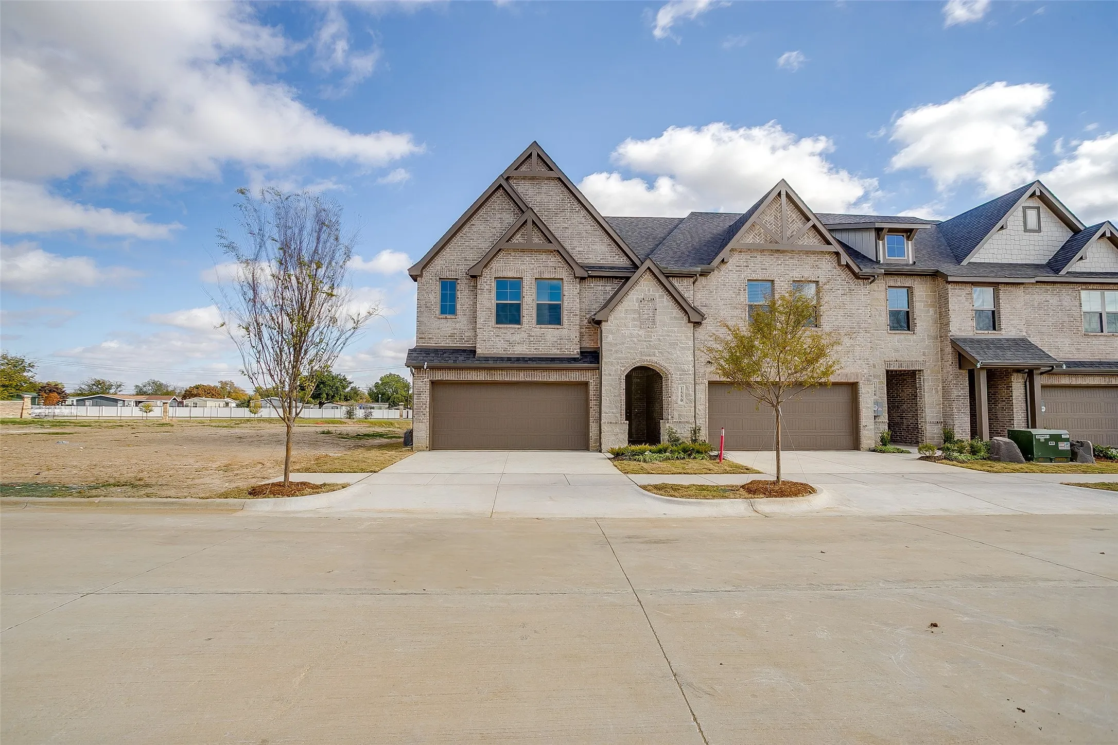 View of front of home featuring driveway, brick siding, and a garage