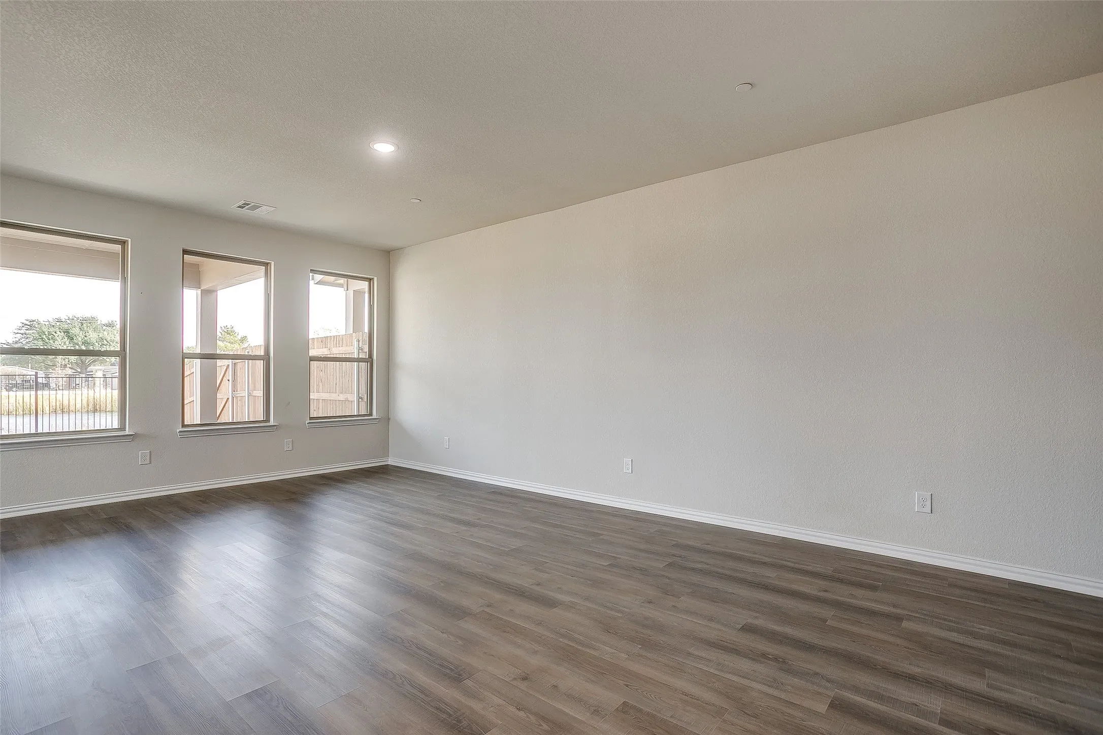 Spare room featuring dark wood-style floors and recessed lighting