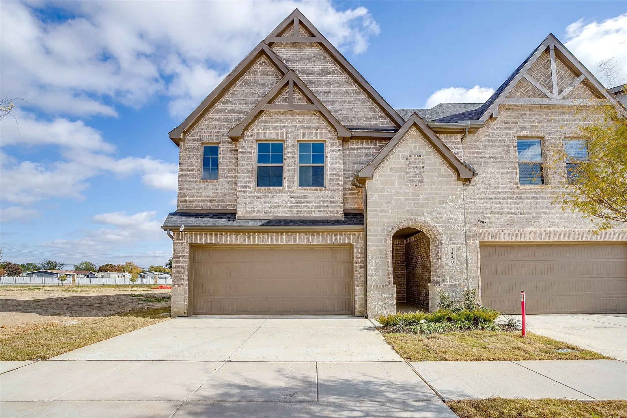 View of front of property with brick siding, concrete driveway, and a garage