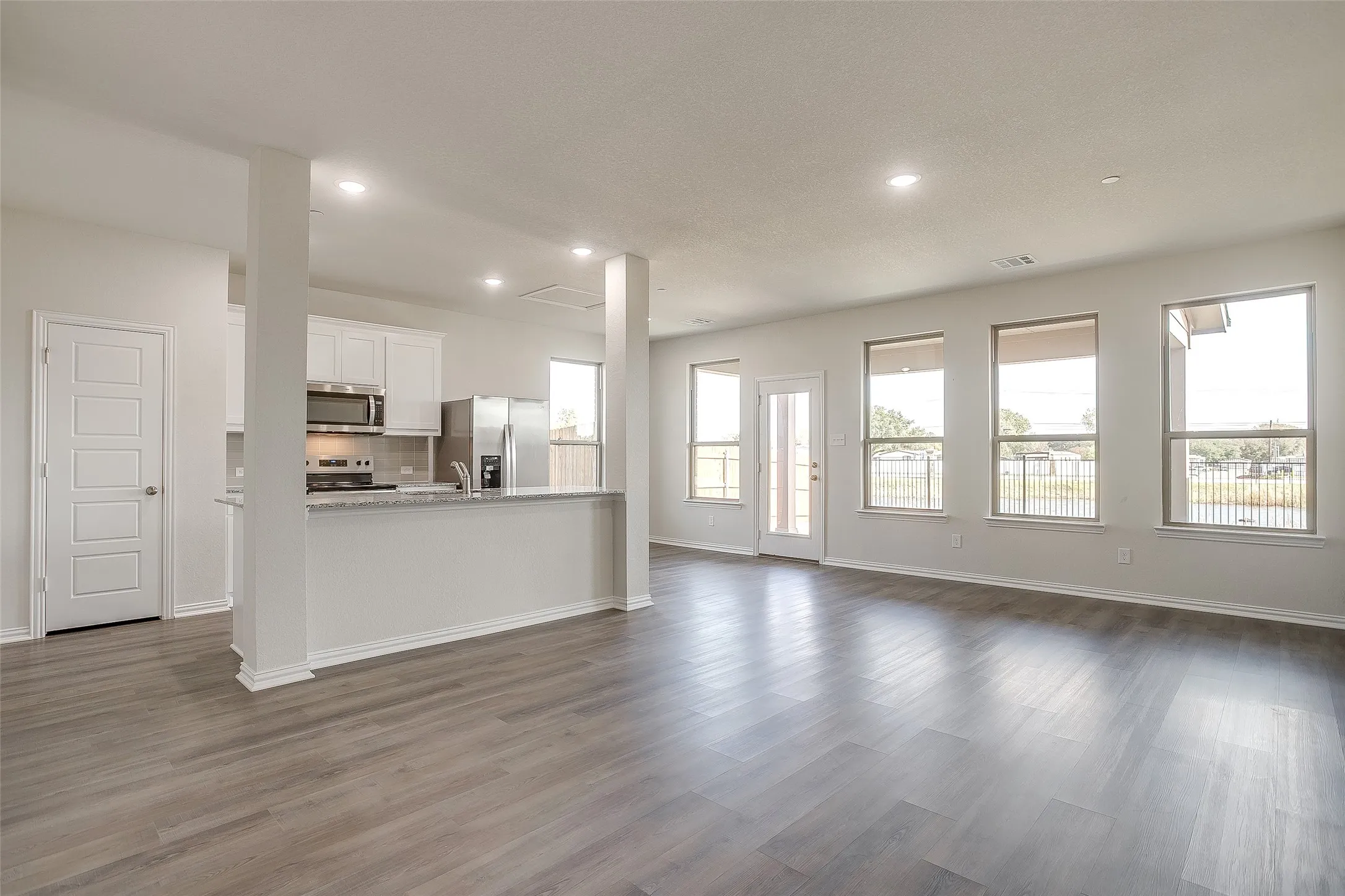 Unfurnished living room featuring dark wood finished floors and recessed lighting