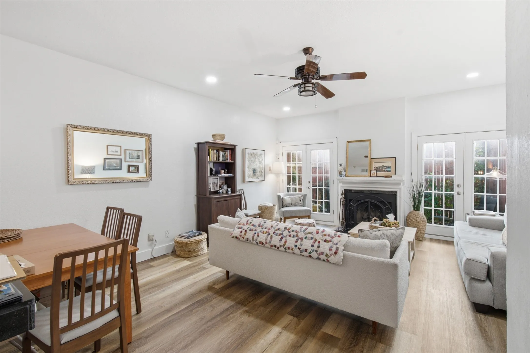 Open-concept living space featuring wood-finish flooring, recessed ceiling lighting, and a ceiling fan