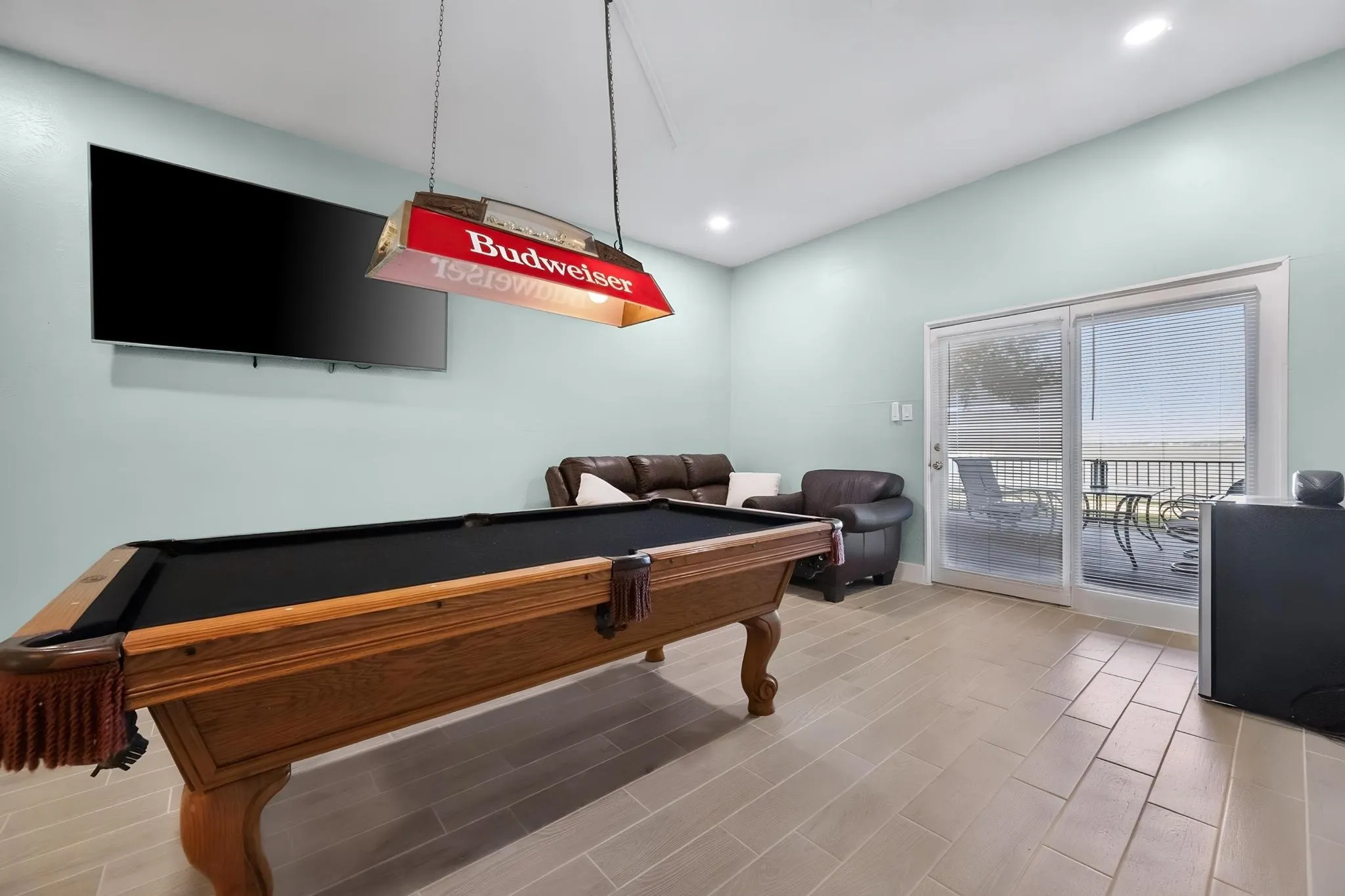 Recessed lighting, light-toned wall color, tile flooring, and sliding glass door leading to a balcony