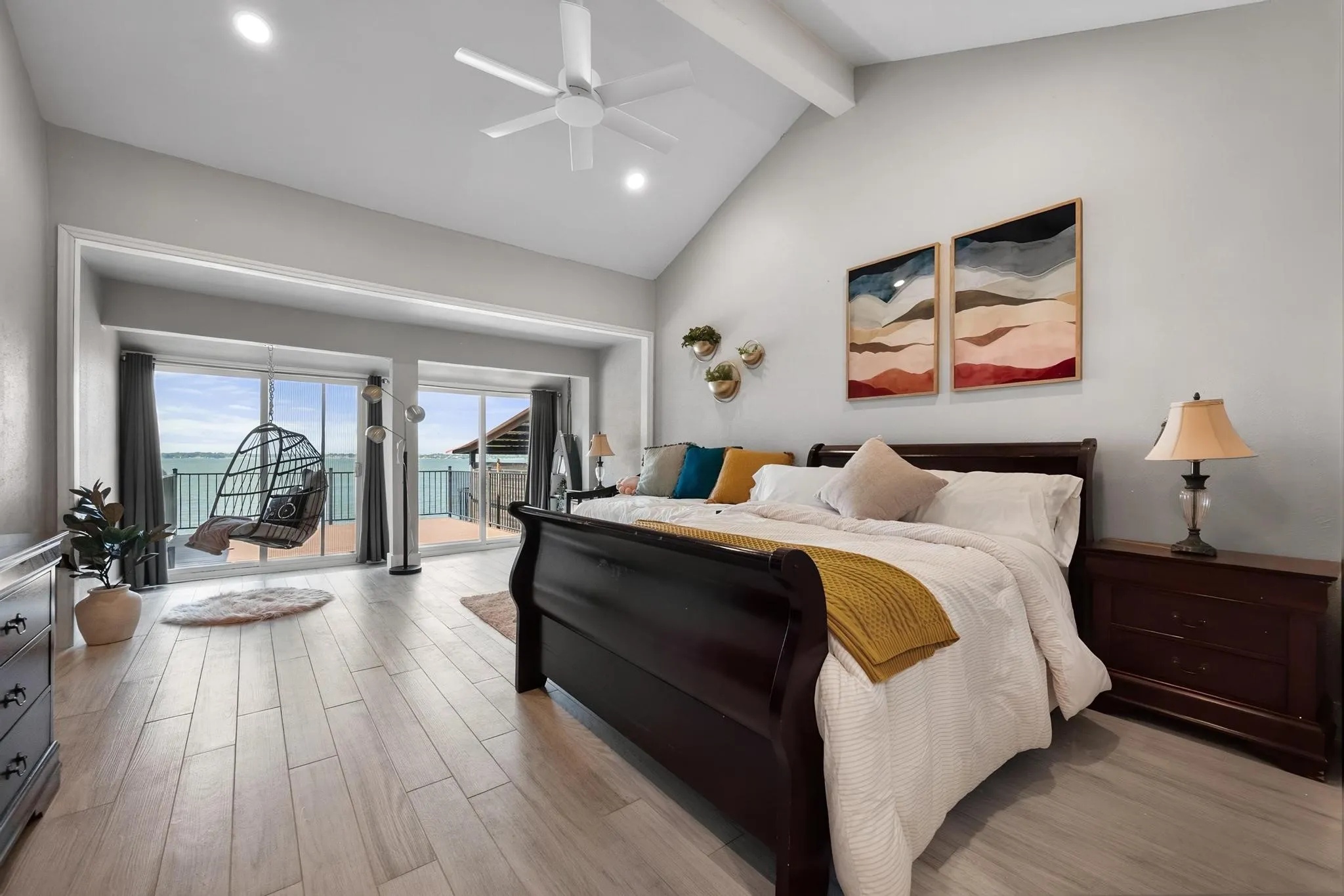 Vaulted ceilings, recessed lighting, wood-finish flooring, sliding glass doors, and a ceiling fan