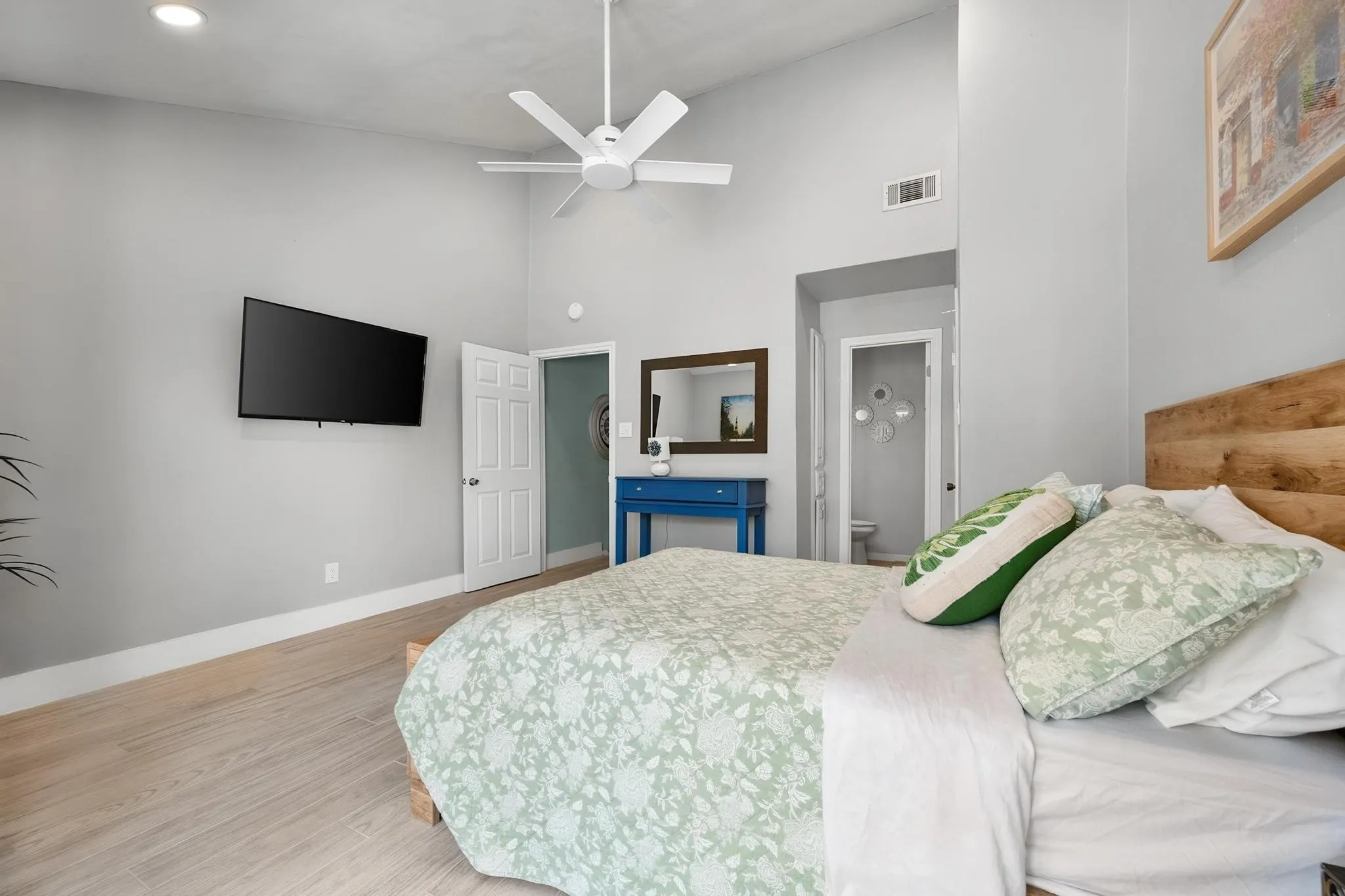Vaulted ceiling with a ceiling fan, recessed lighting, and light wood-finish flooring